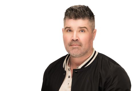 Portrait of a man in a black jacket against a white background