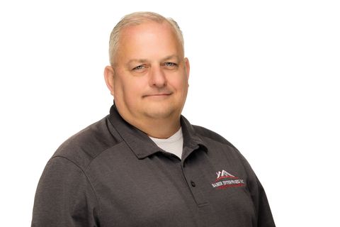 Portrait of a man in a dark gray polo shirt against a white background
