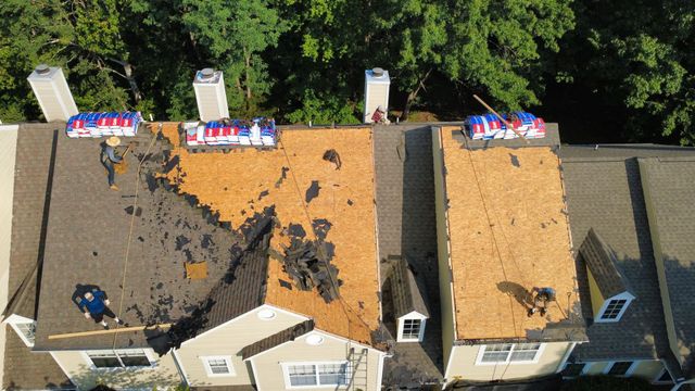 Roof tear-off in progress on a row of townhomes