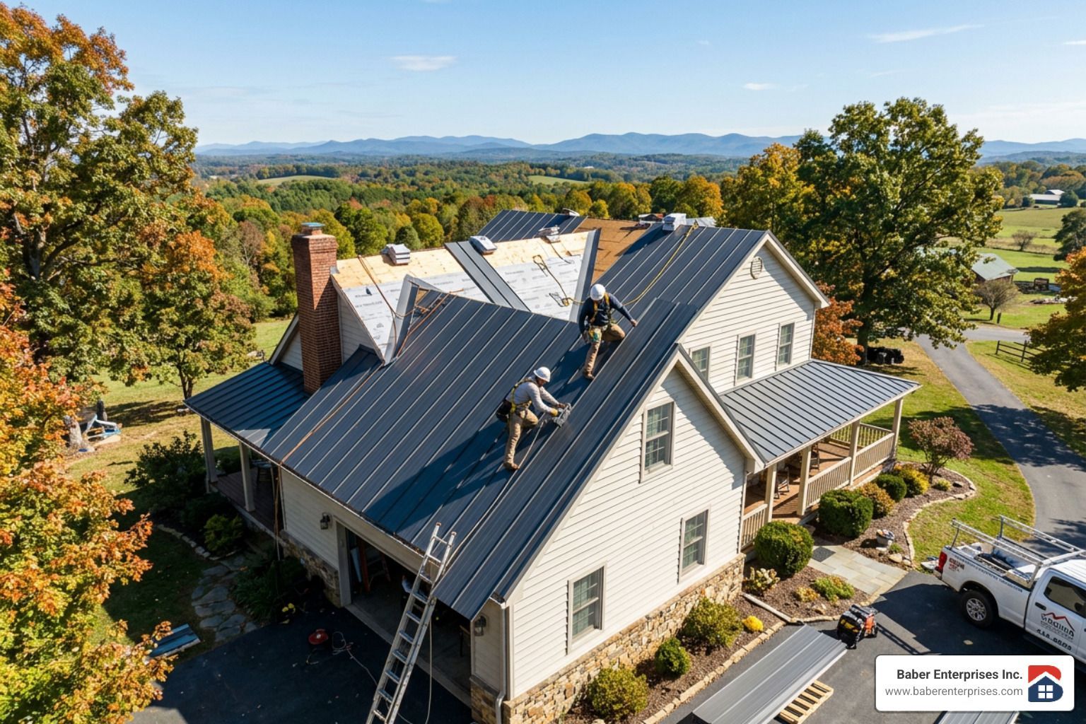 Aerial view of a house with a dark roof, two workers on top, surrounded by trees and open landscape.