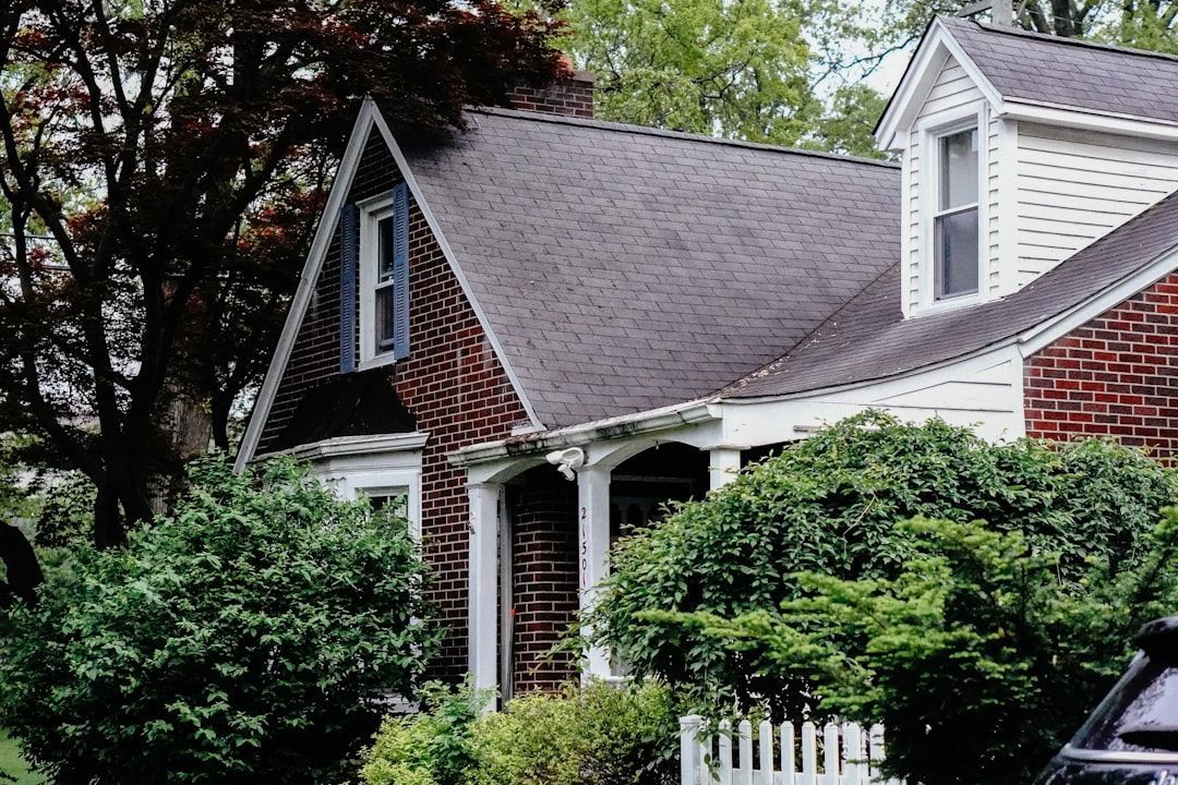 Brick Cape Cod home with a weathered asphalt shingle roof and dormer