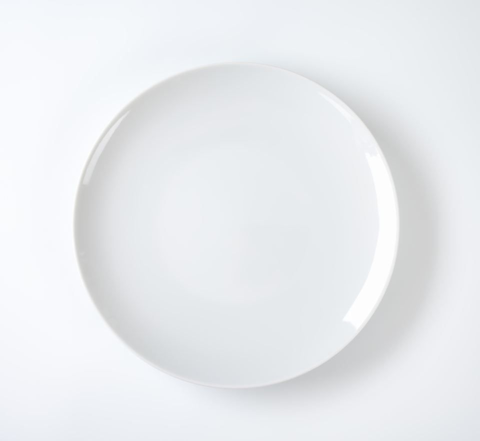 A single, empty, white ceramic plate centered on a light gray background.