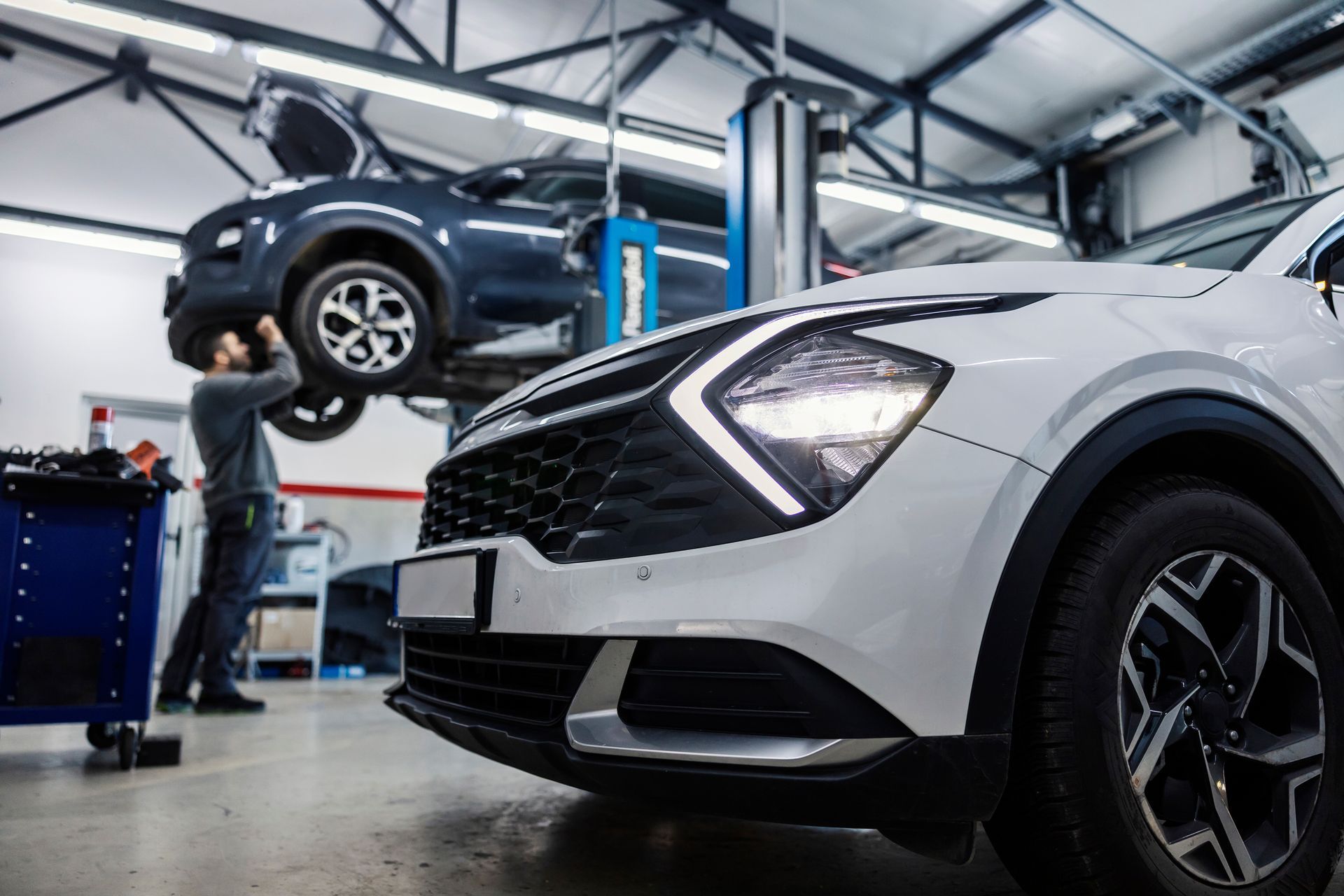 A mechanic working on a car raised on a lift in a car repair shop | Martin’s Auto Care