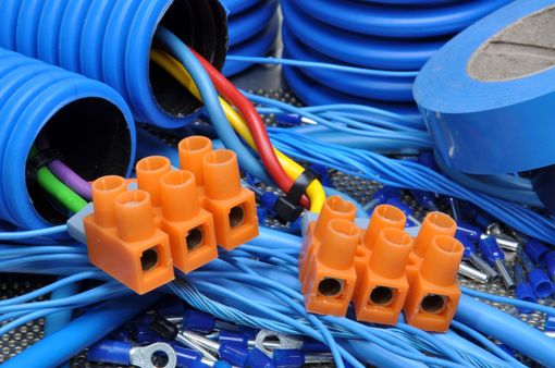 Cavi elettrici blu e arancioni con connettori arancioni su un banco da lavoro.