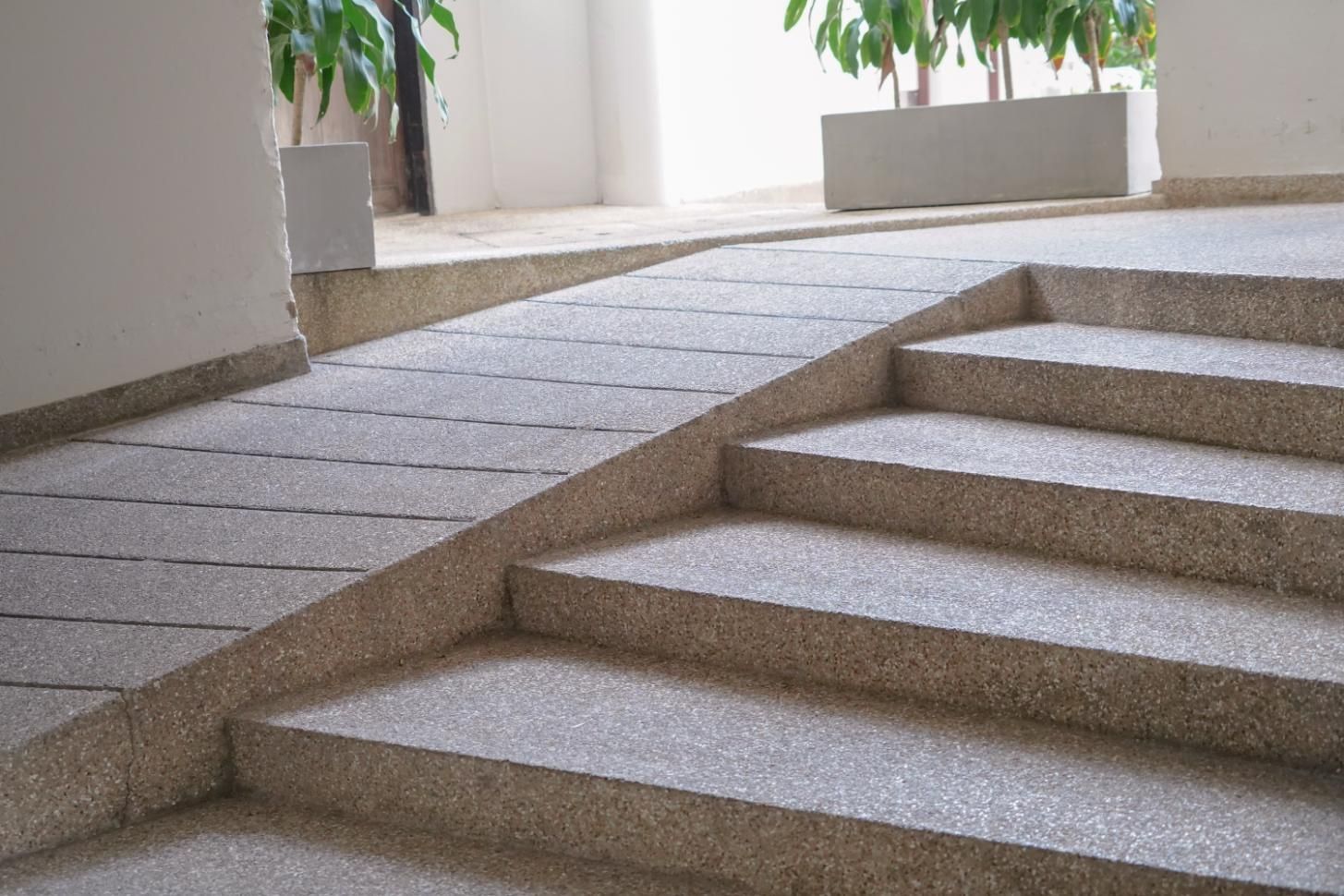 Ramp and stairs side-by-side; gray speckled concrete. 