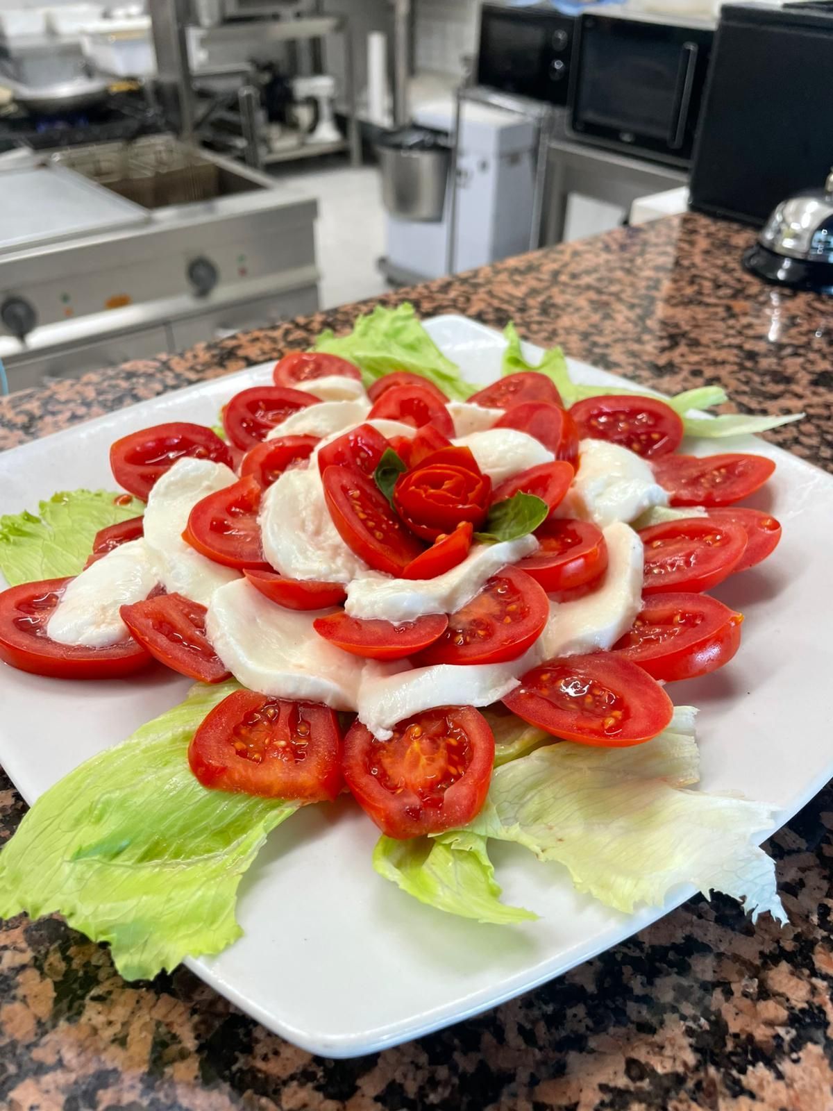 Insalata di fragole e panna montata disposta su lattuga su un piatto bianco in cucina