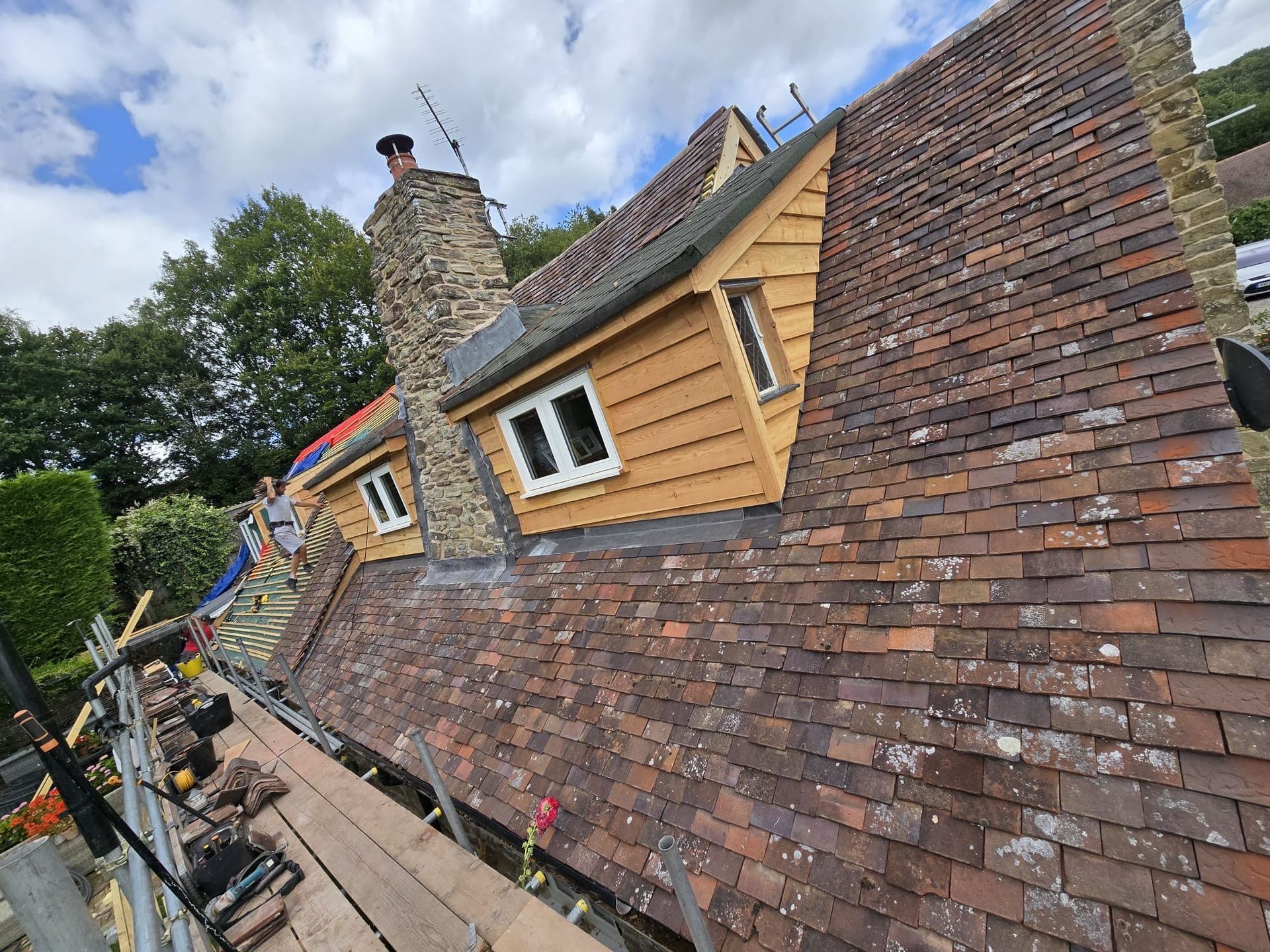 A house with a brick roof and a chimney on top of it.