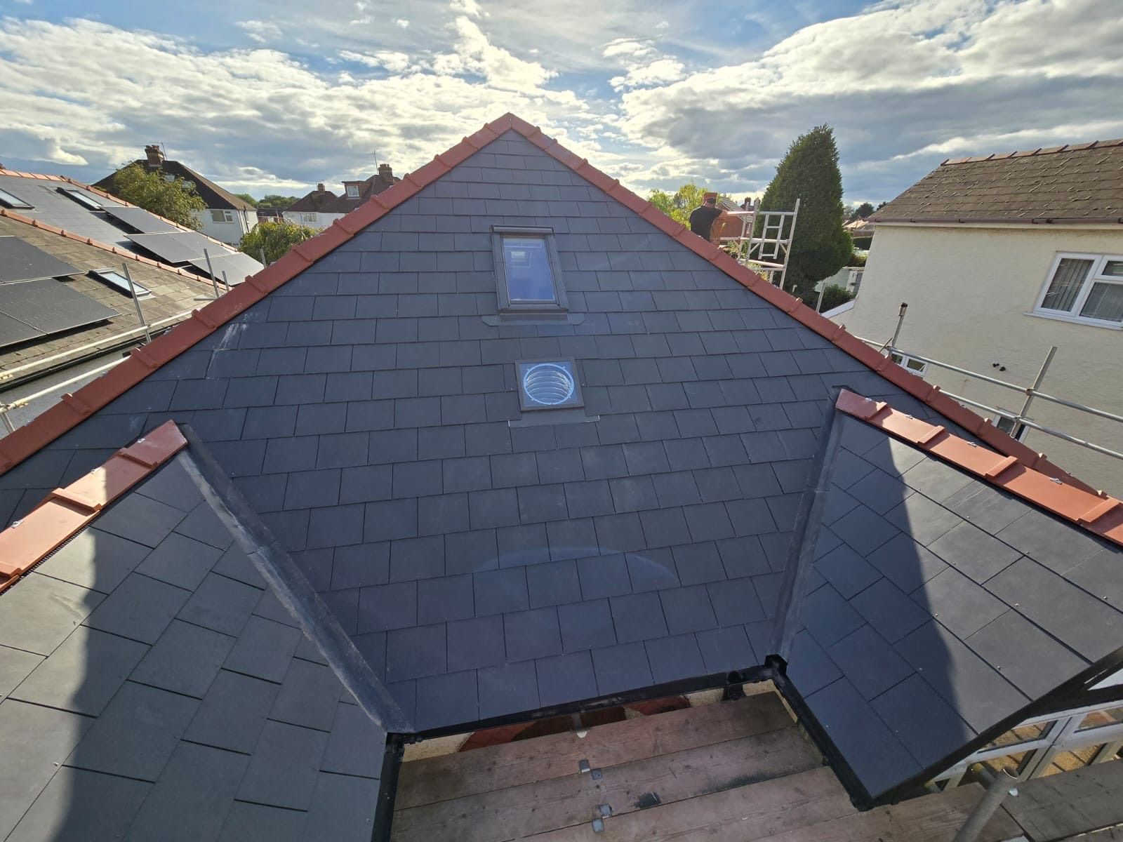 A roof with a triangle shaped roof and two windows on it.