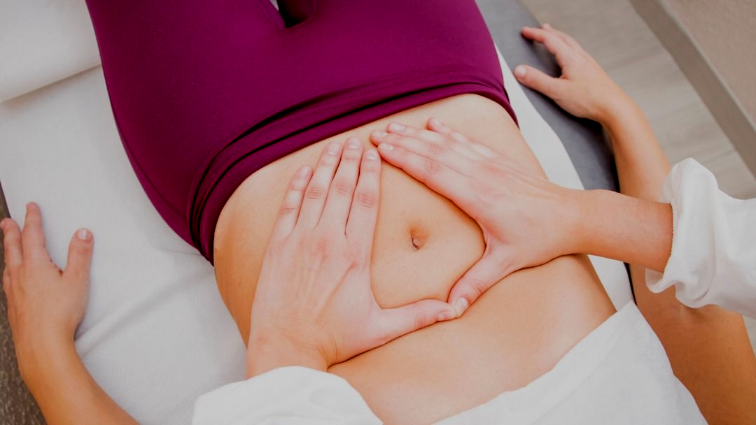 Mani con unghie arancioni che coprono delicatamente il seno.