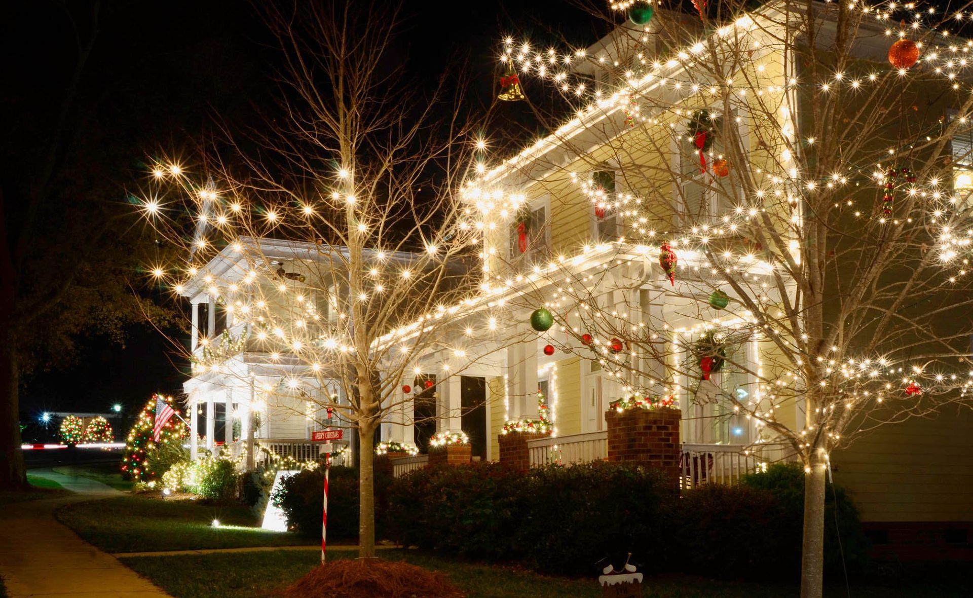 House decorated with Christmas lights at night; front porch with colorful ornaments.