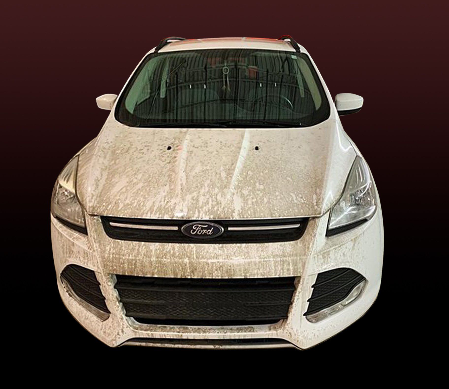 White Ford SUV covered in dirt, front view, against a dark background.