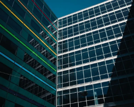 Modern glass office buildings with reflective blue windows and diagonal shadows