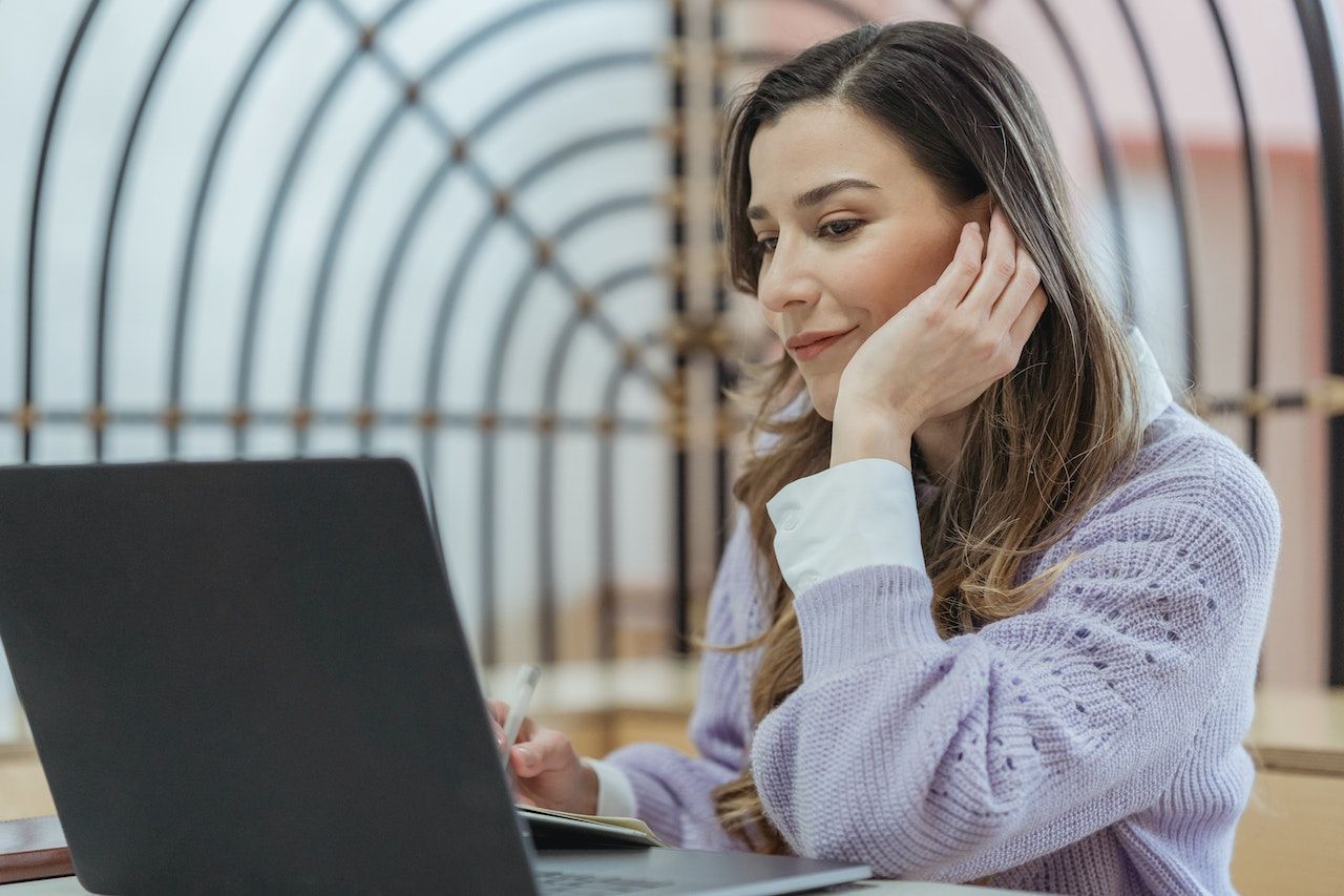 A woman with a laptop researching buying a salvage title car