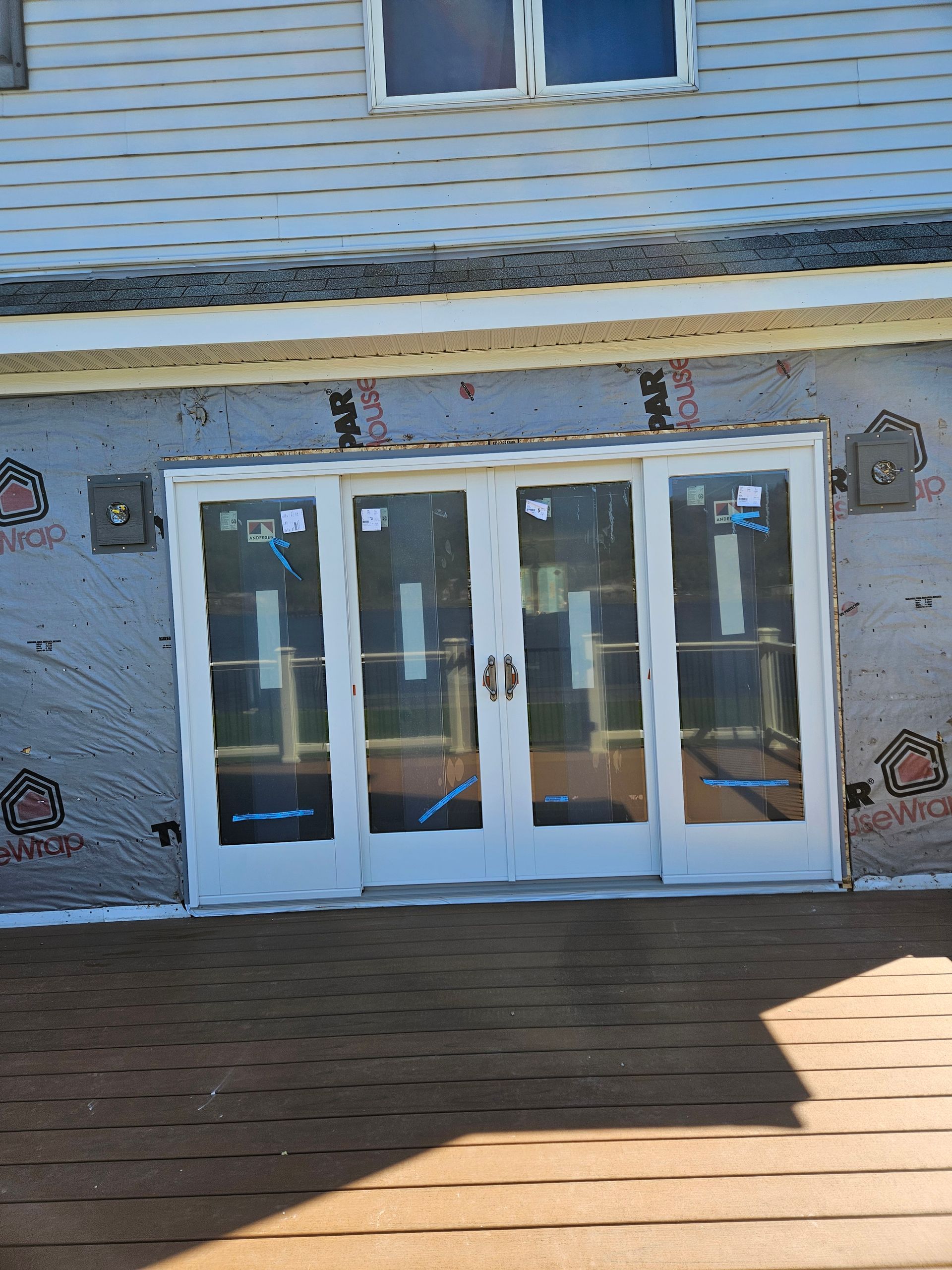 White storefront entrance with glass double doors and side panels beneath a small window.