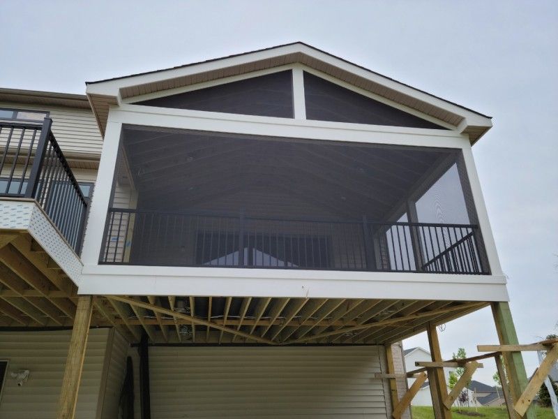 Screened porch with black screens, white trim, and black railing on a wooden deck.