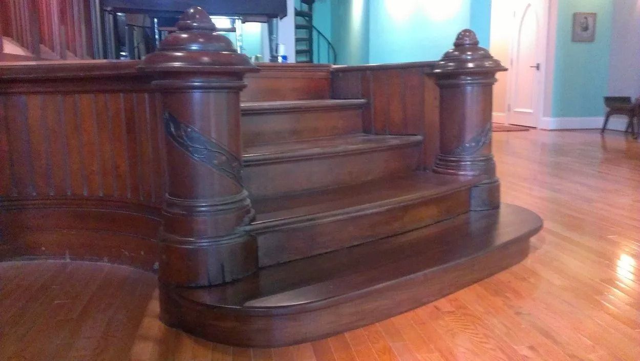 Dark wooden staircase with carved banister in a polished interior room
