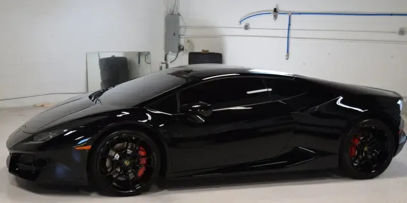 A black lamborghini huracan is parked in a garage.