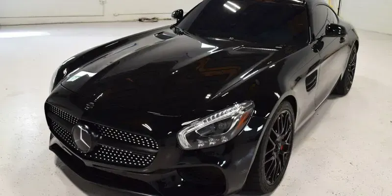 A black mercedes benz sl63 amg is parked in a garage.