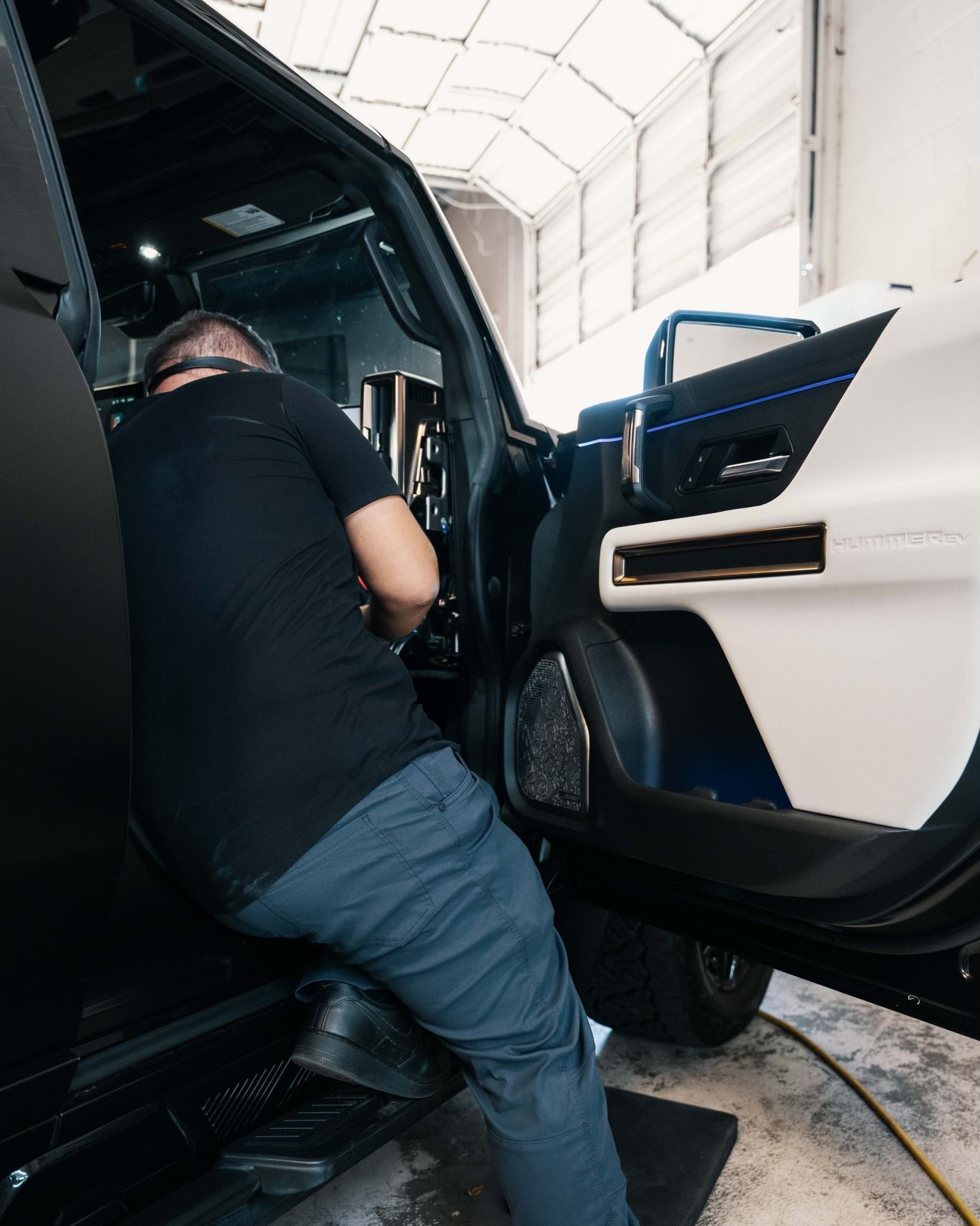 A man is working on a car in a garage.