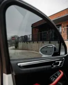 A car is parked in front of a brick building.