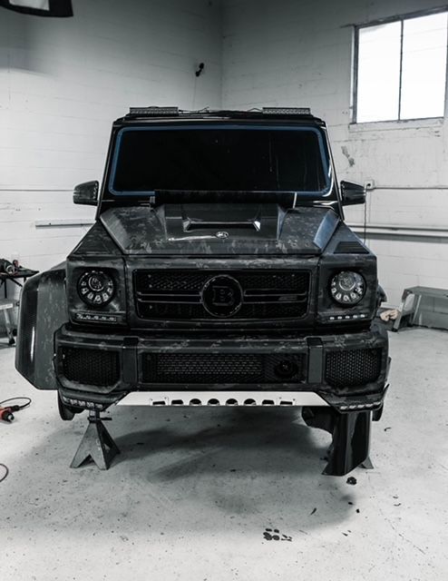 A black mercedes benz is parked in a garage