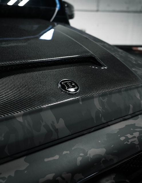 A close up of the hood of a car with the letter b on it