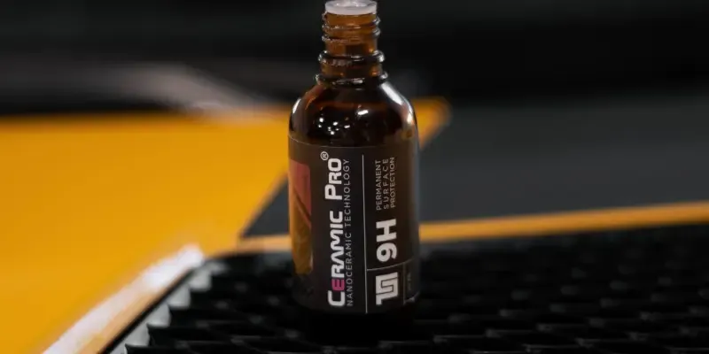 A bottle of ceramic pro is sitting on top of a keyboard.