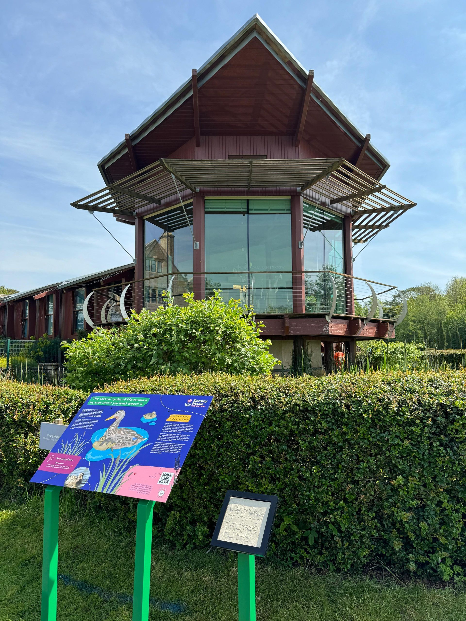 A large wooden house with a sign in front of it.