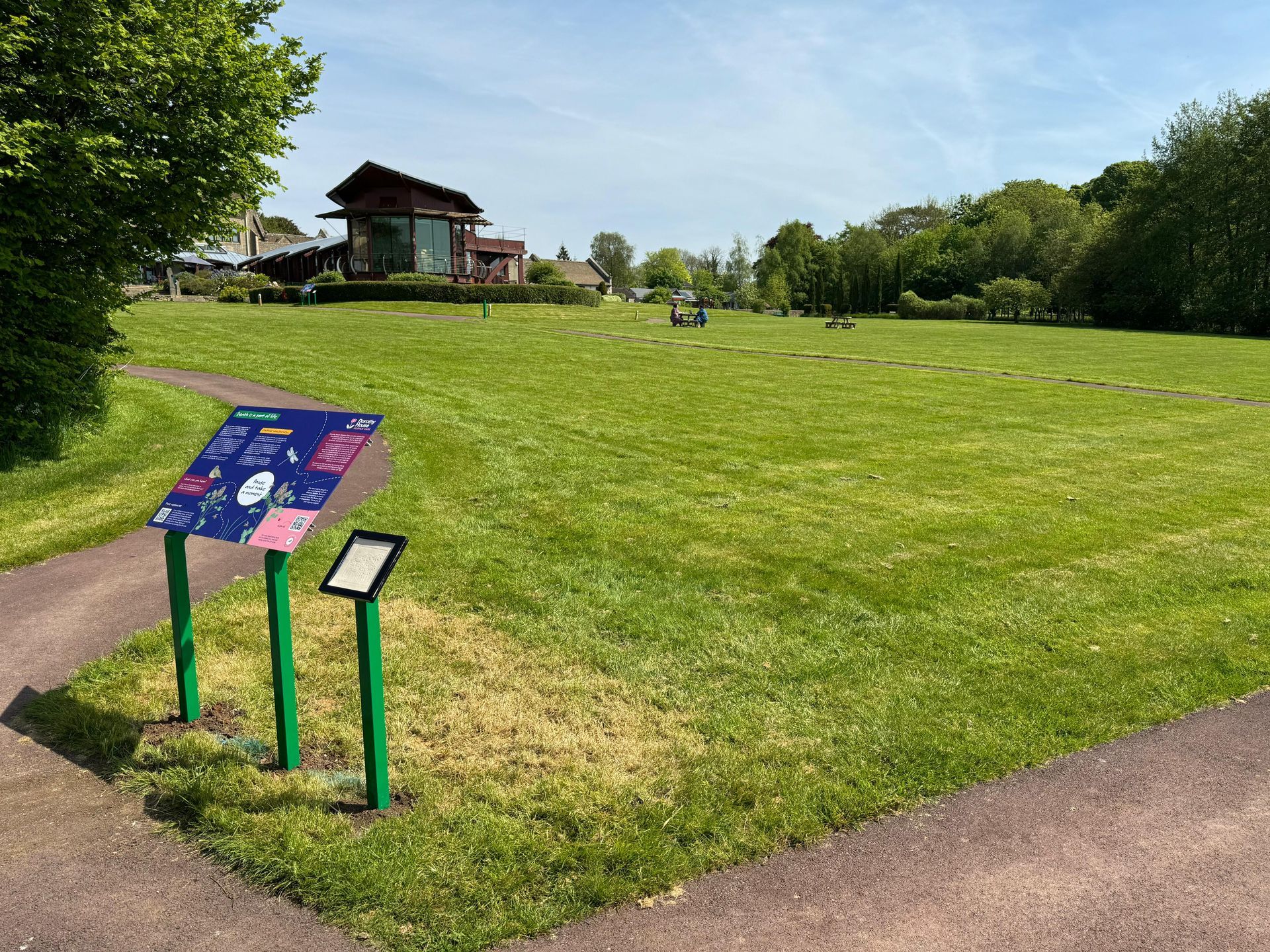 There is a sign in the middle of a grassy field.