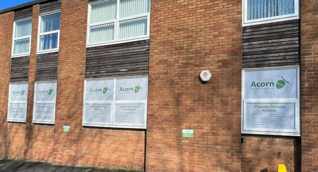 A brick building with a lot of windows and signs on it.