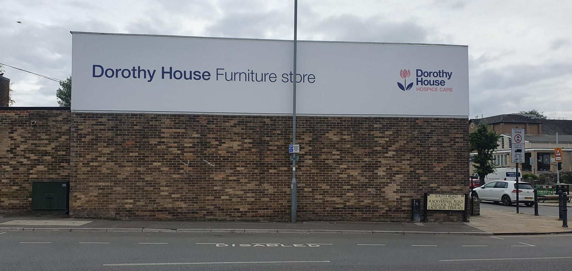 A large billboard on the side of a building that says dorothy house furniture store