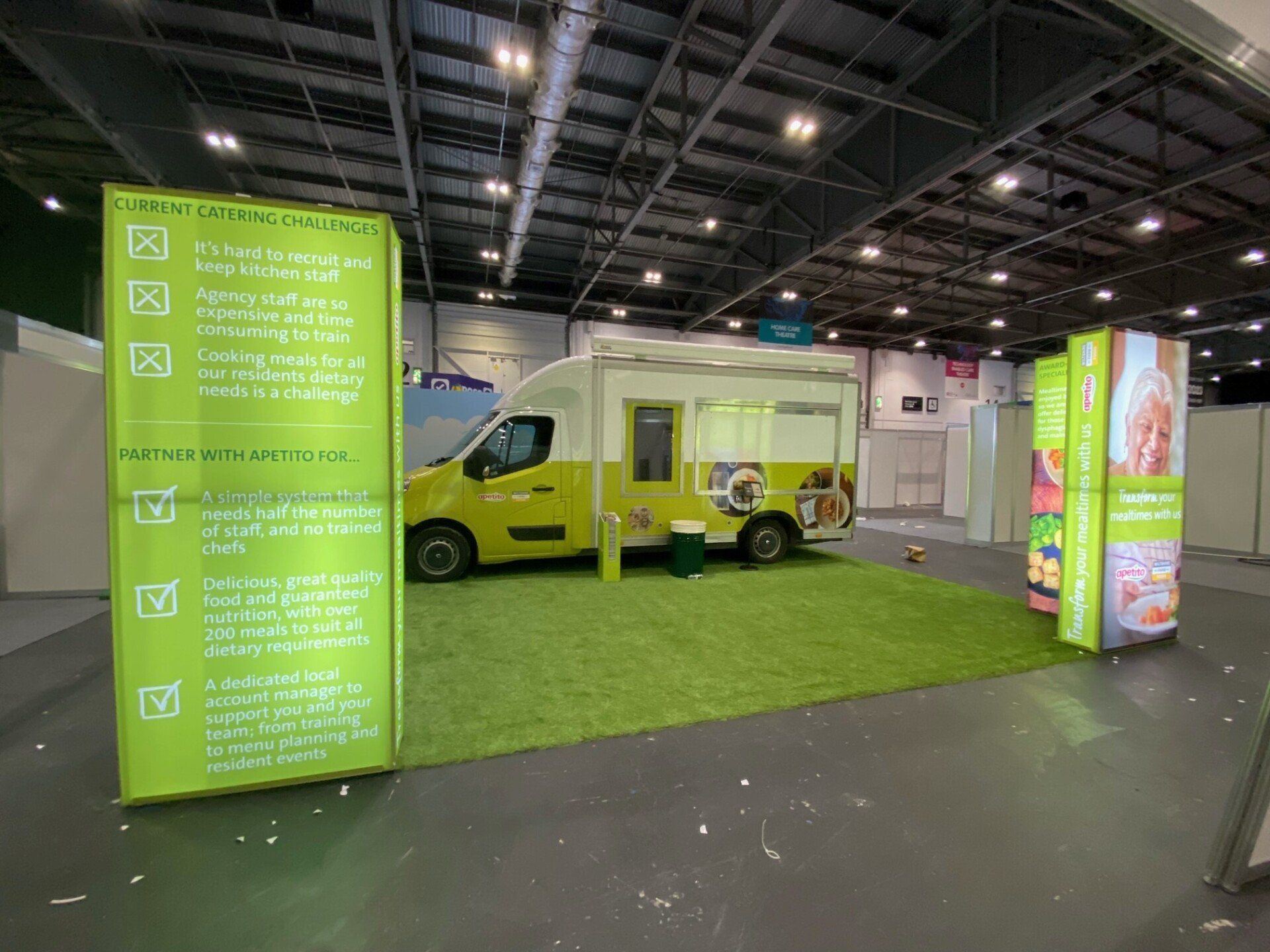 A yellow food truck is parked in a large room.