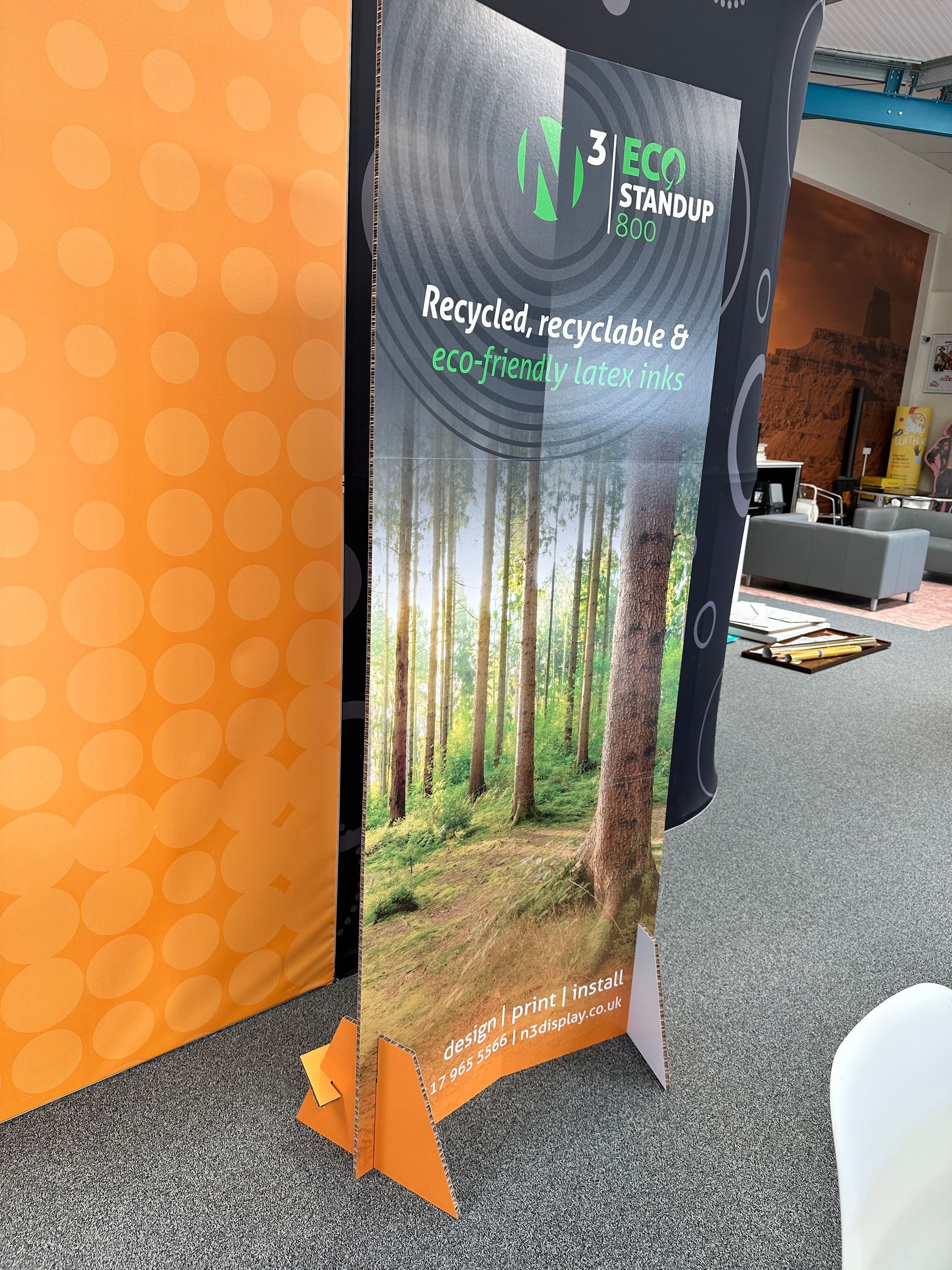 A cardboard sign with a picture of a forest on it