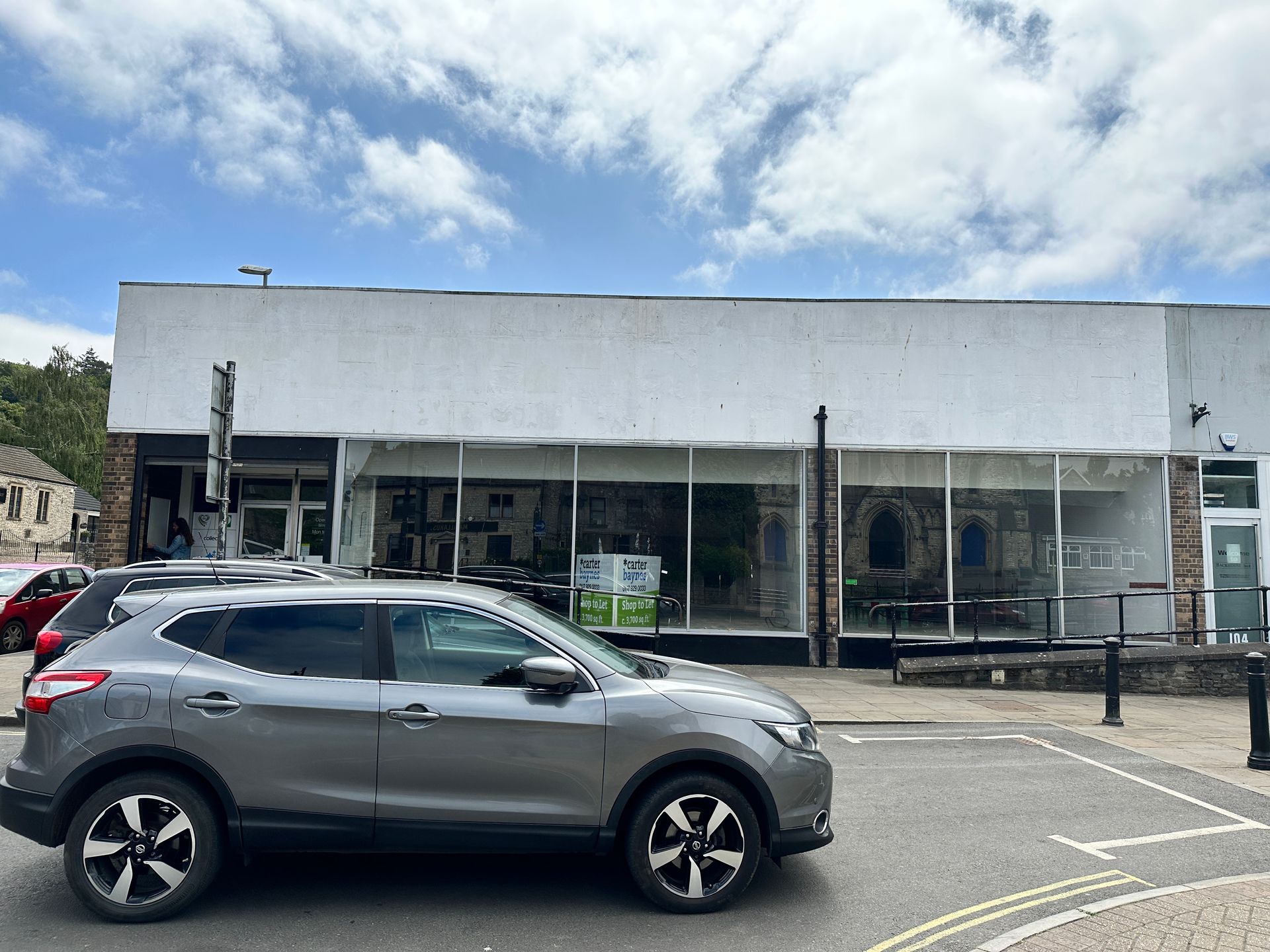 A car is parked in front of a building.