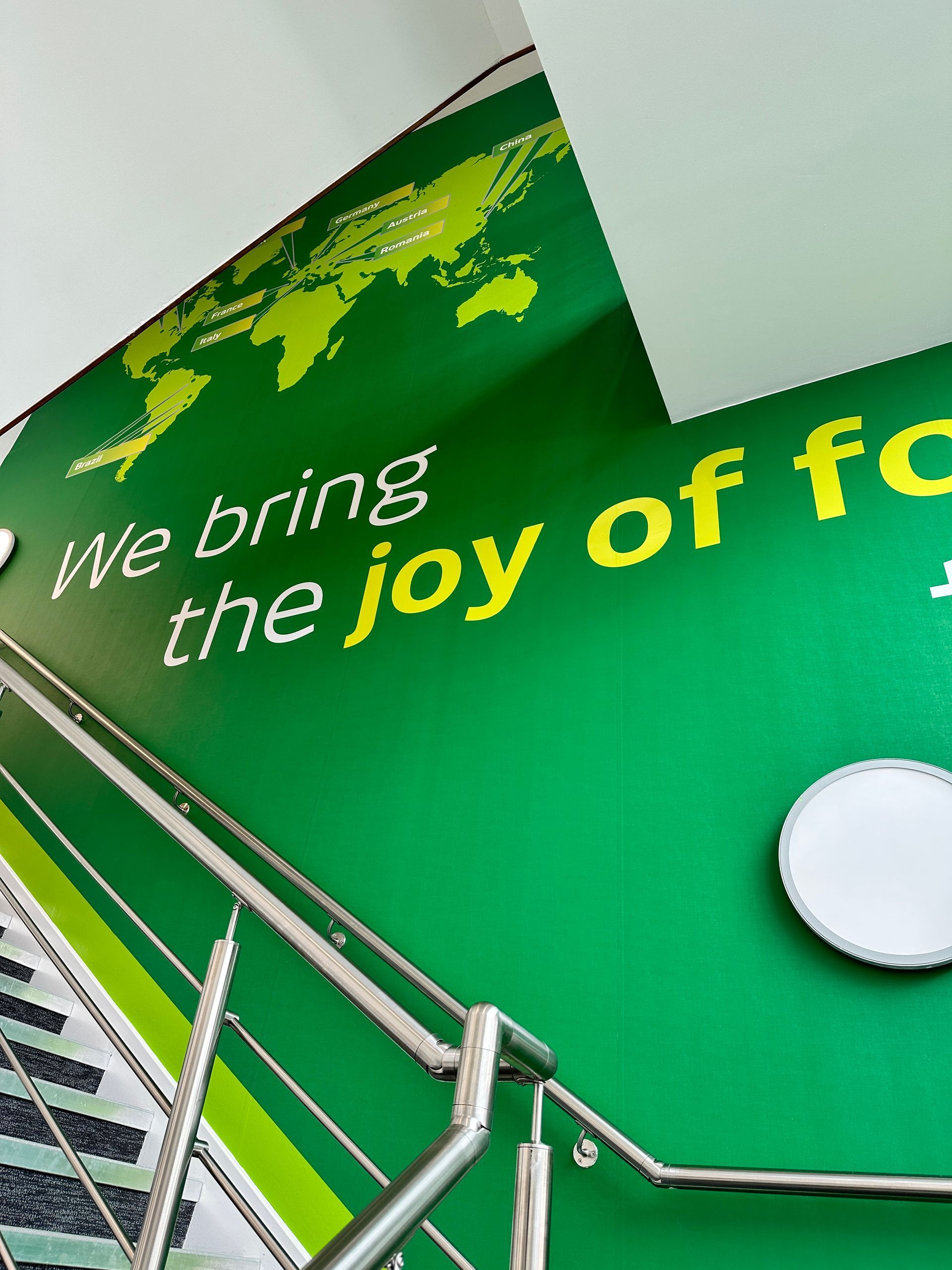 A green wall with the words we bring the joy of fc written on it