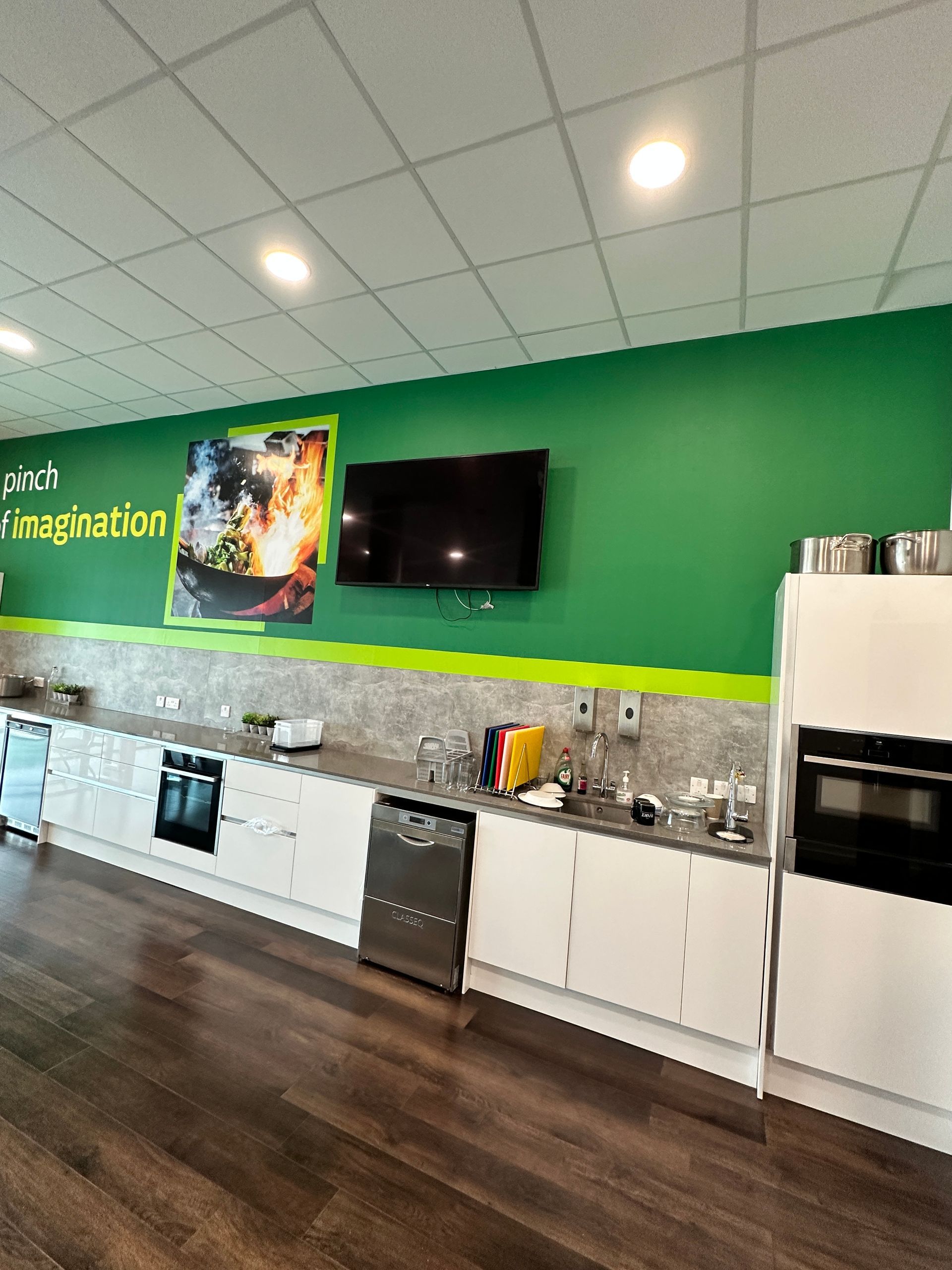A kitchen with a green wall and a sign that says imagination