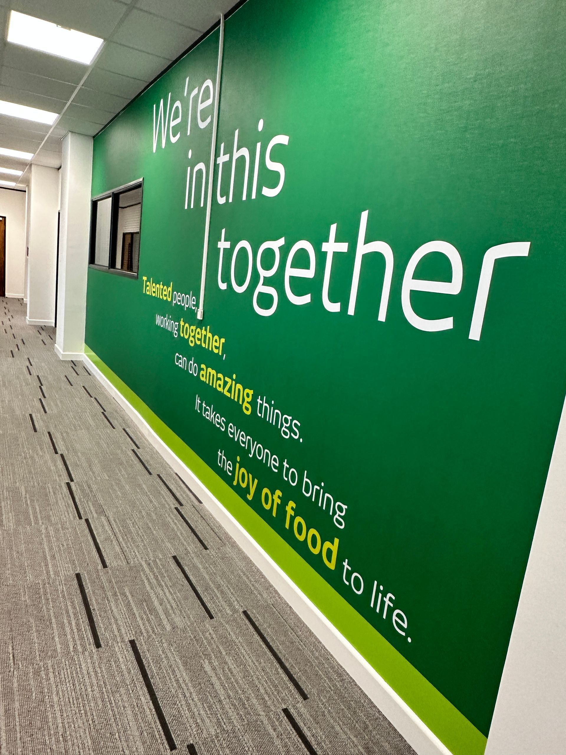 A green wall with the words `` here in this together '' written on it