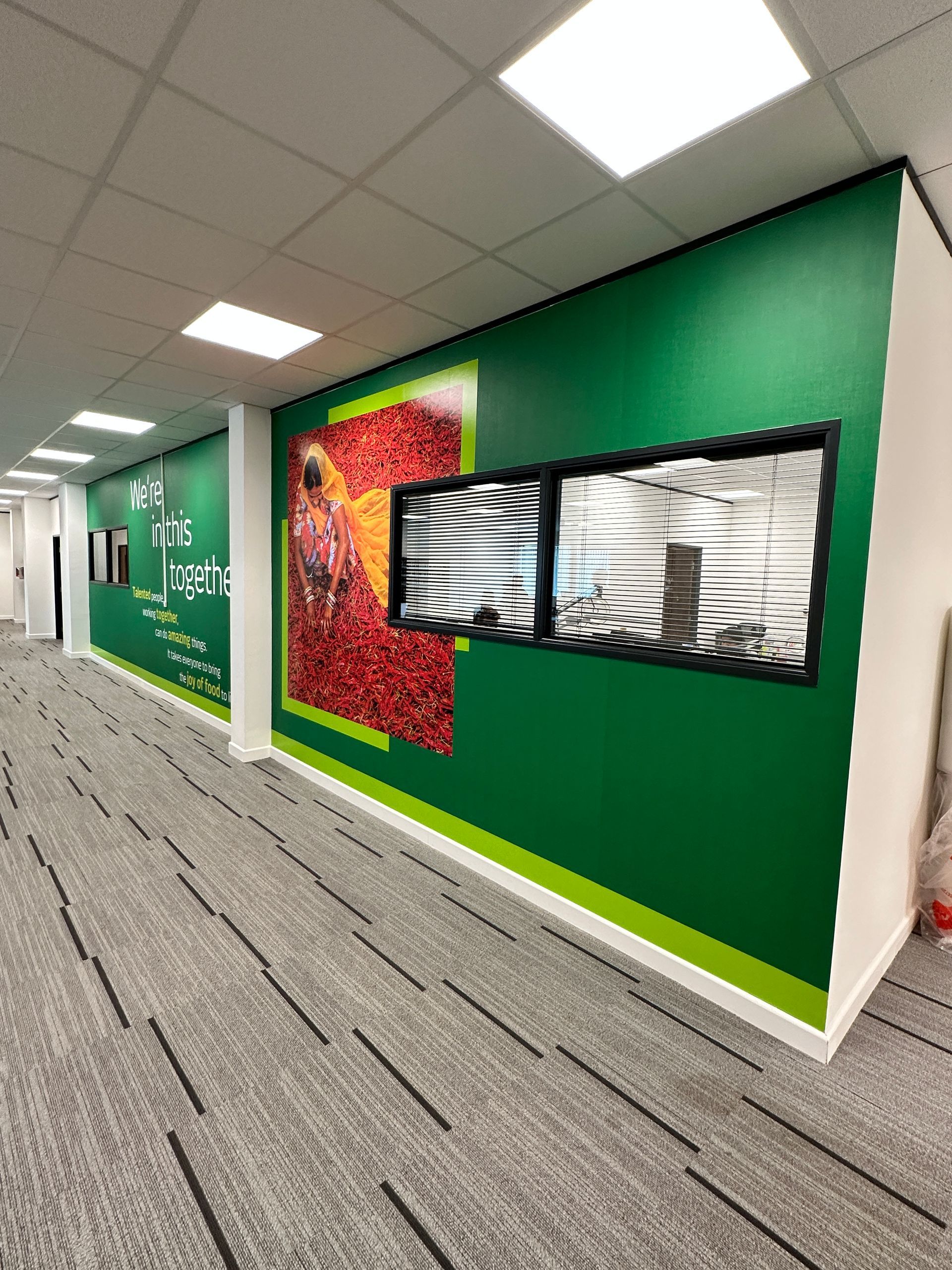 A hallway with green walls and a carpeted floor.