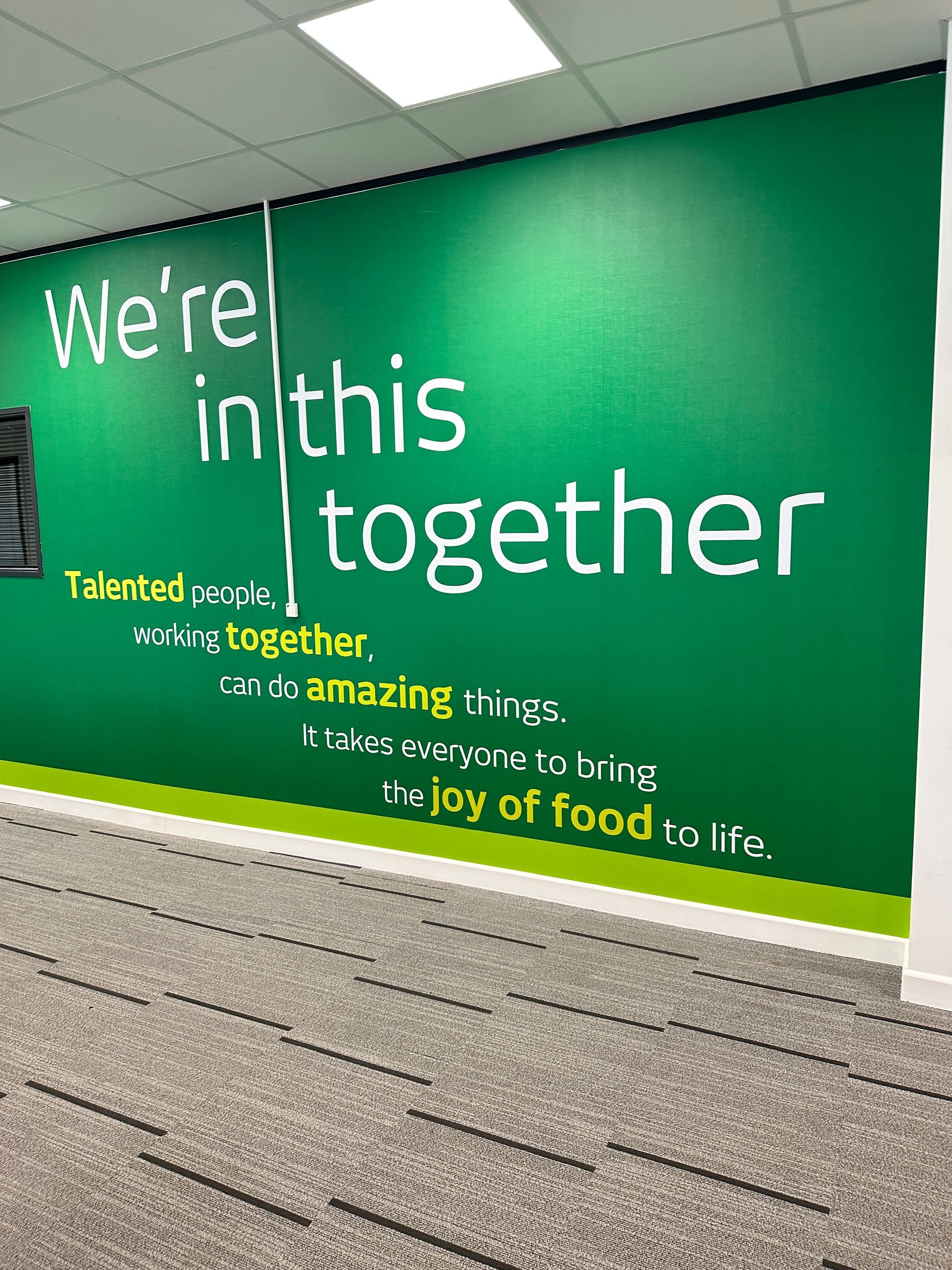 A green wall with the words `` we 're in this together '' written on it