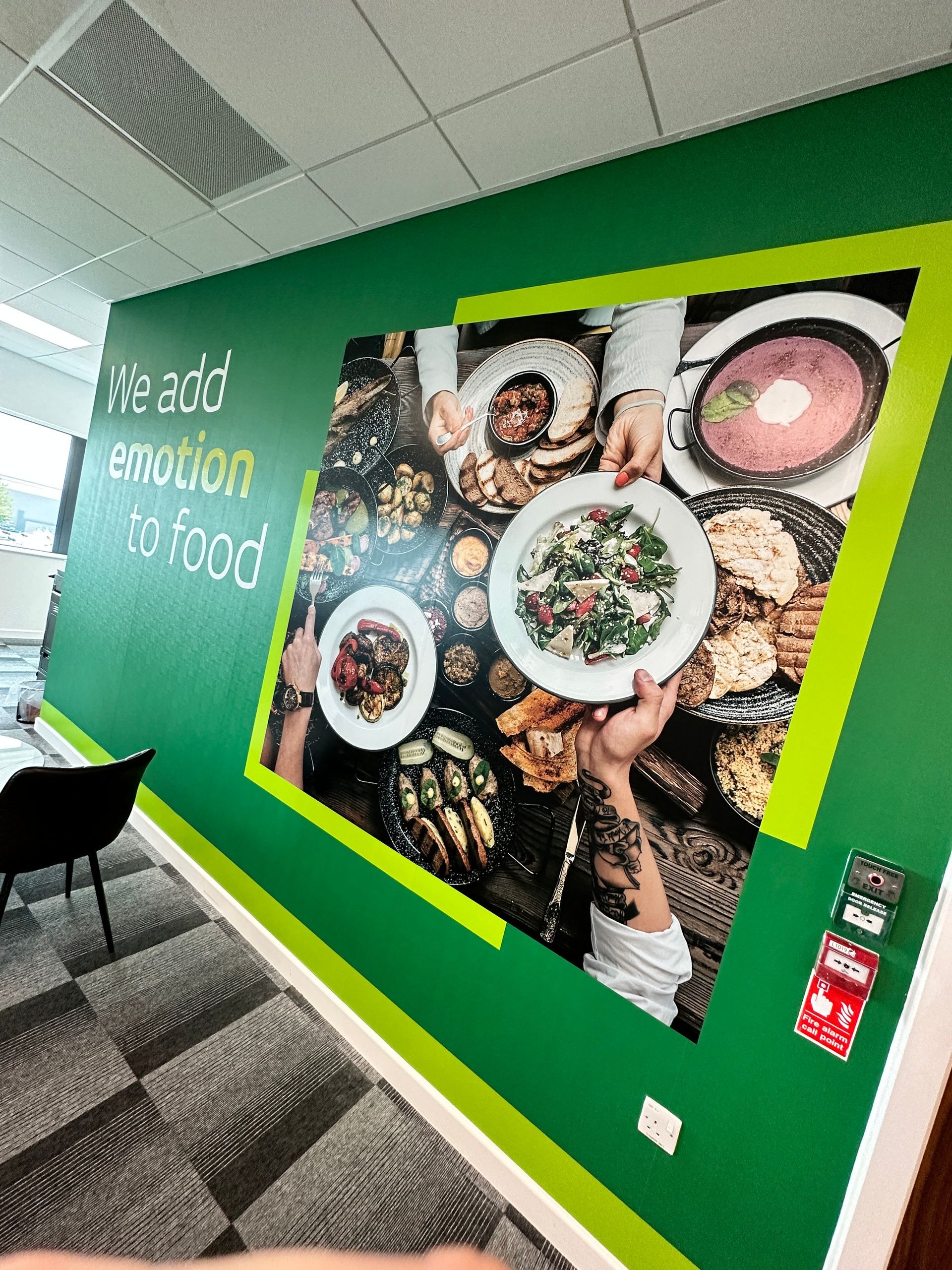 A green wall with a picture of people eating food on it.
