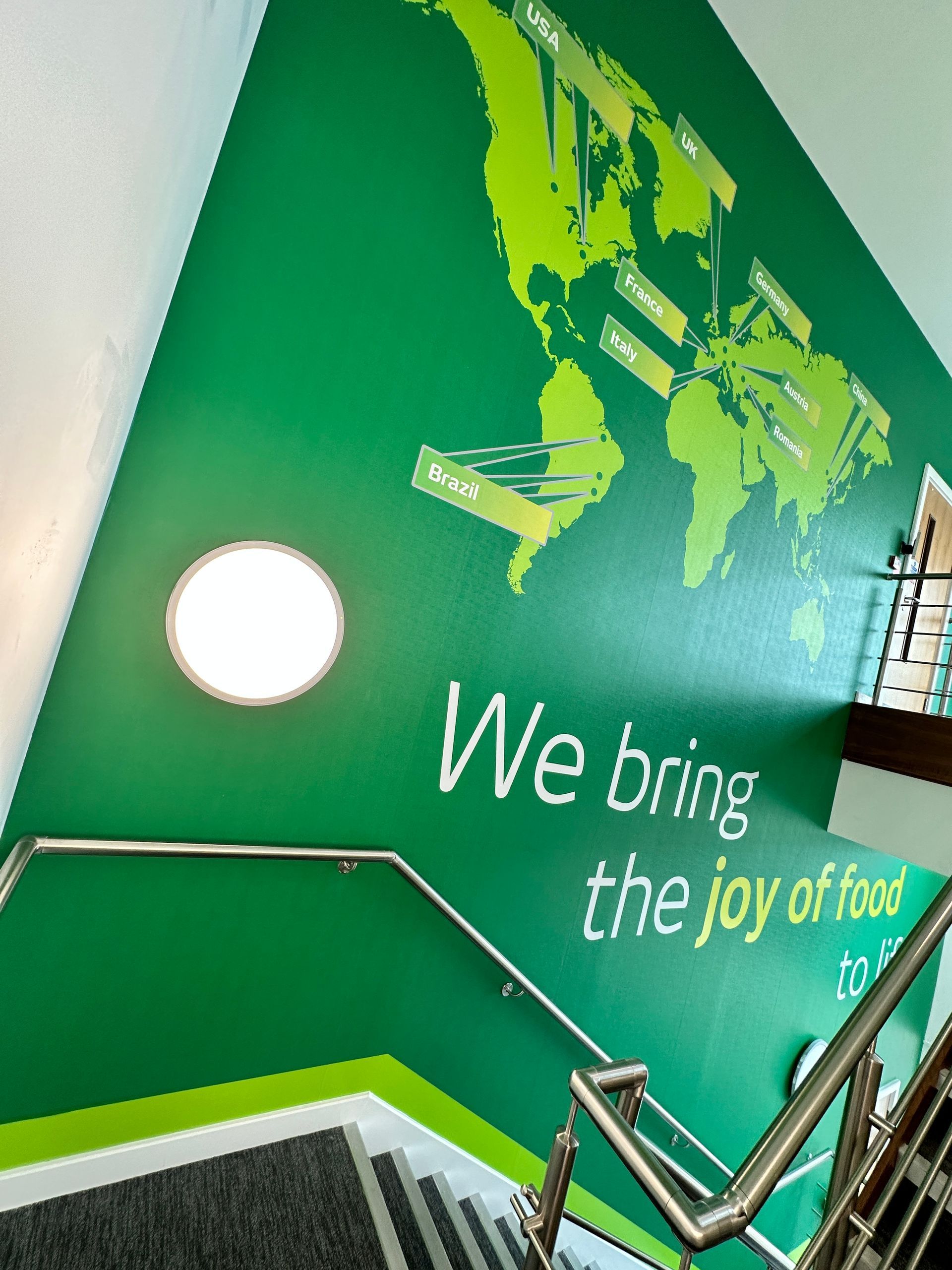 A green wall with the words we bring the joy of food on it