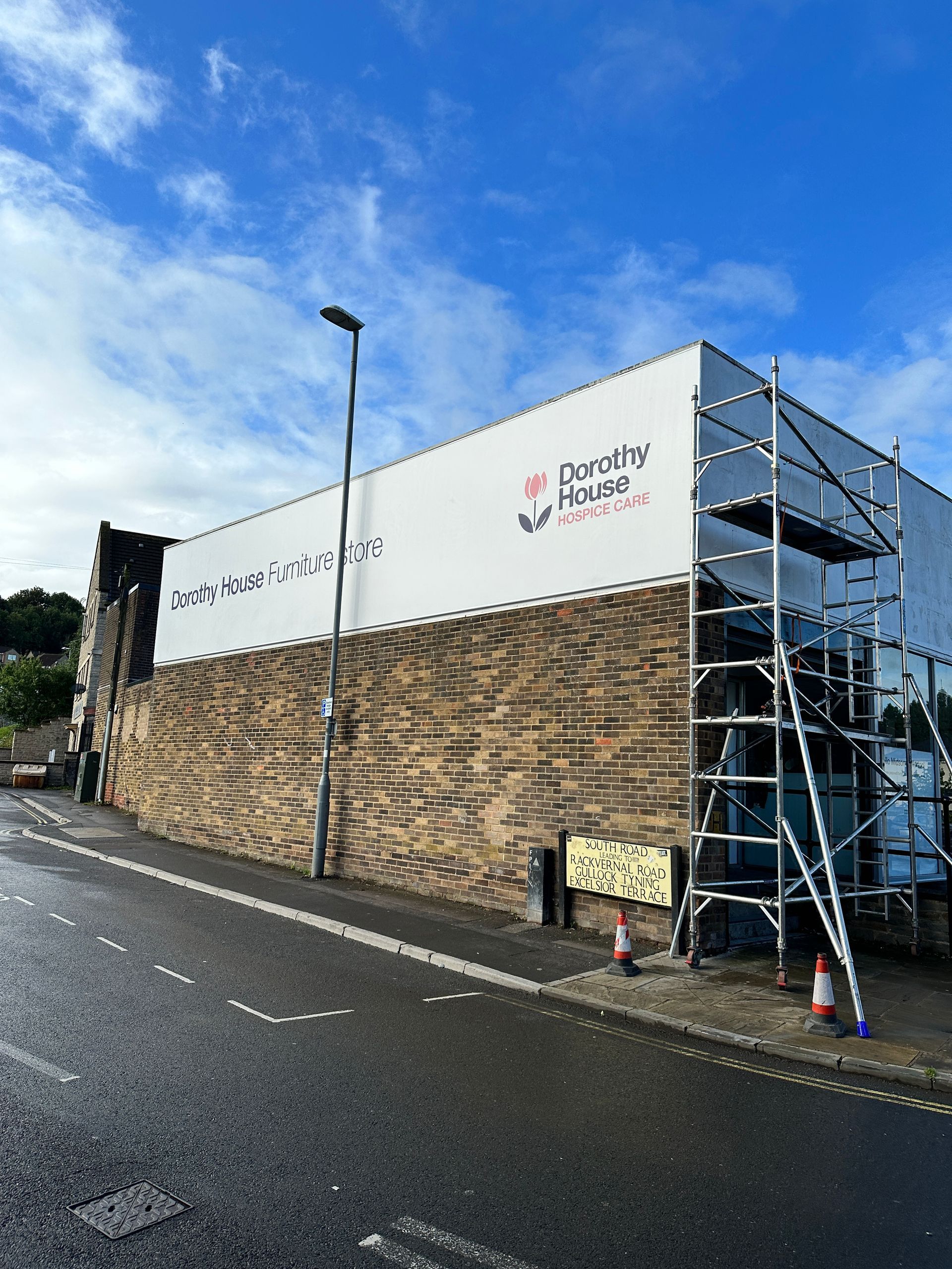A building with scaffolding on the side of it is being painted.