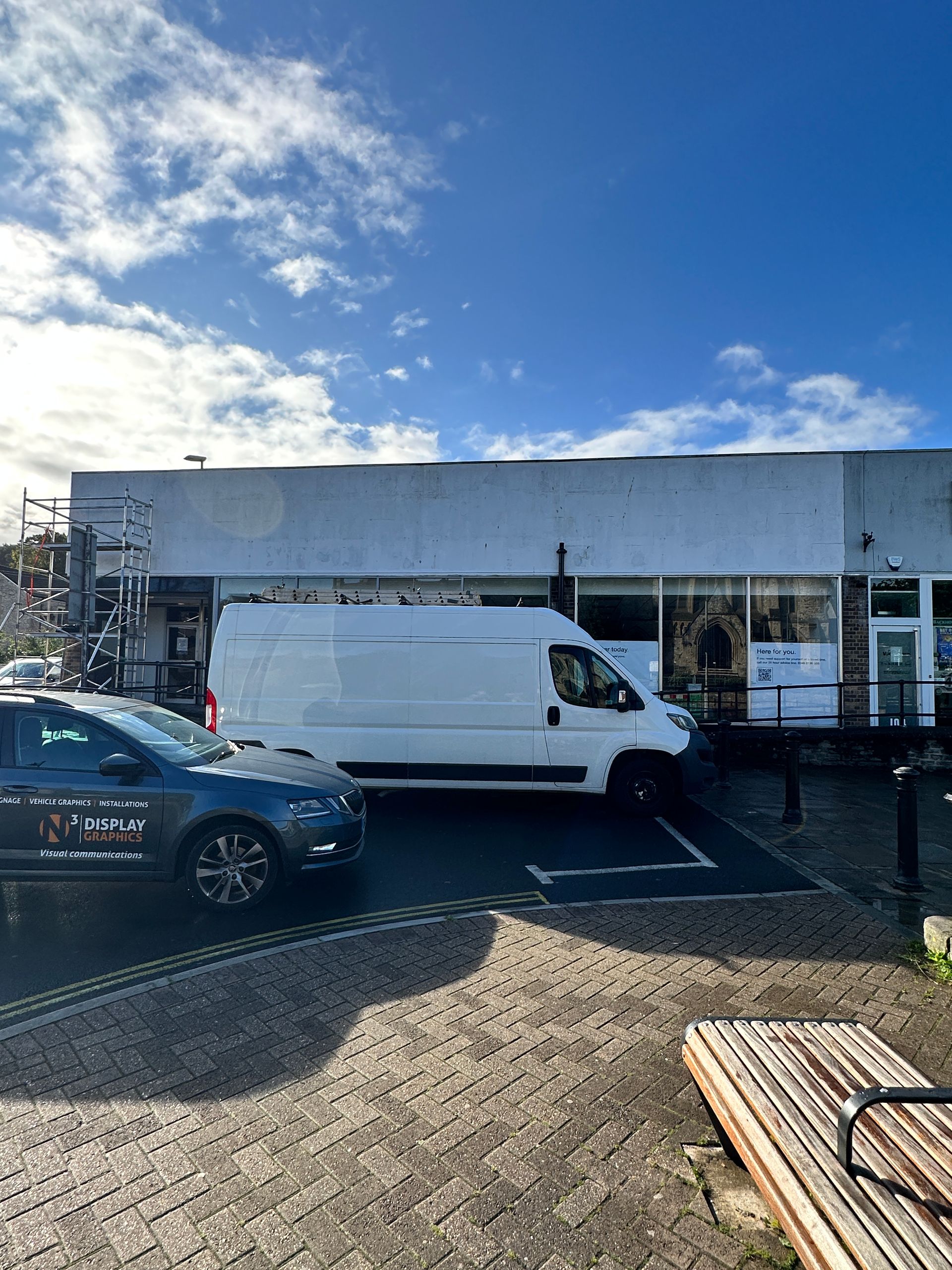 A white van is parked in front of a building.