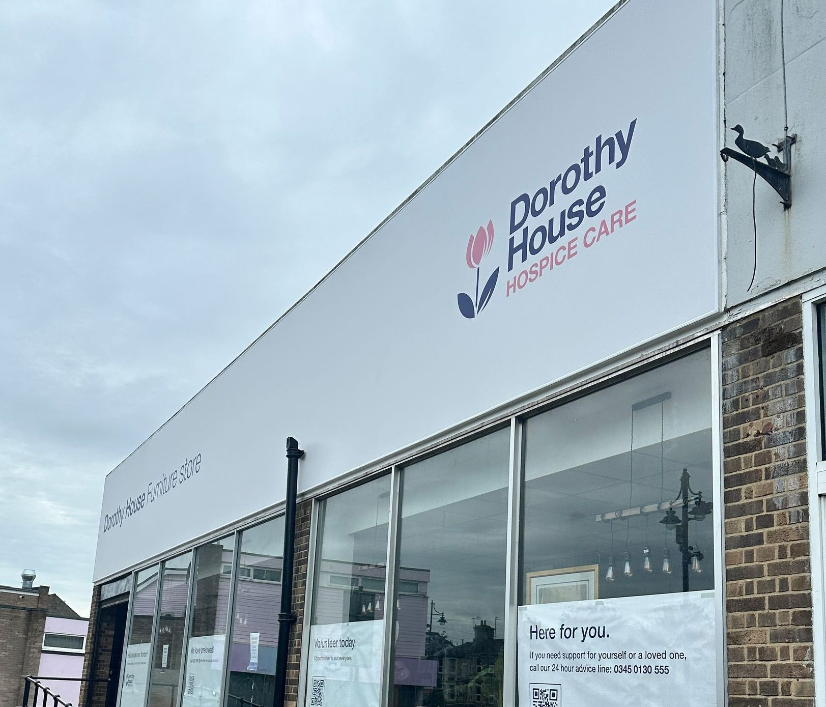 A white building with a sign that says dorothy house hospice care