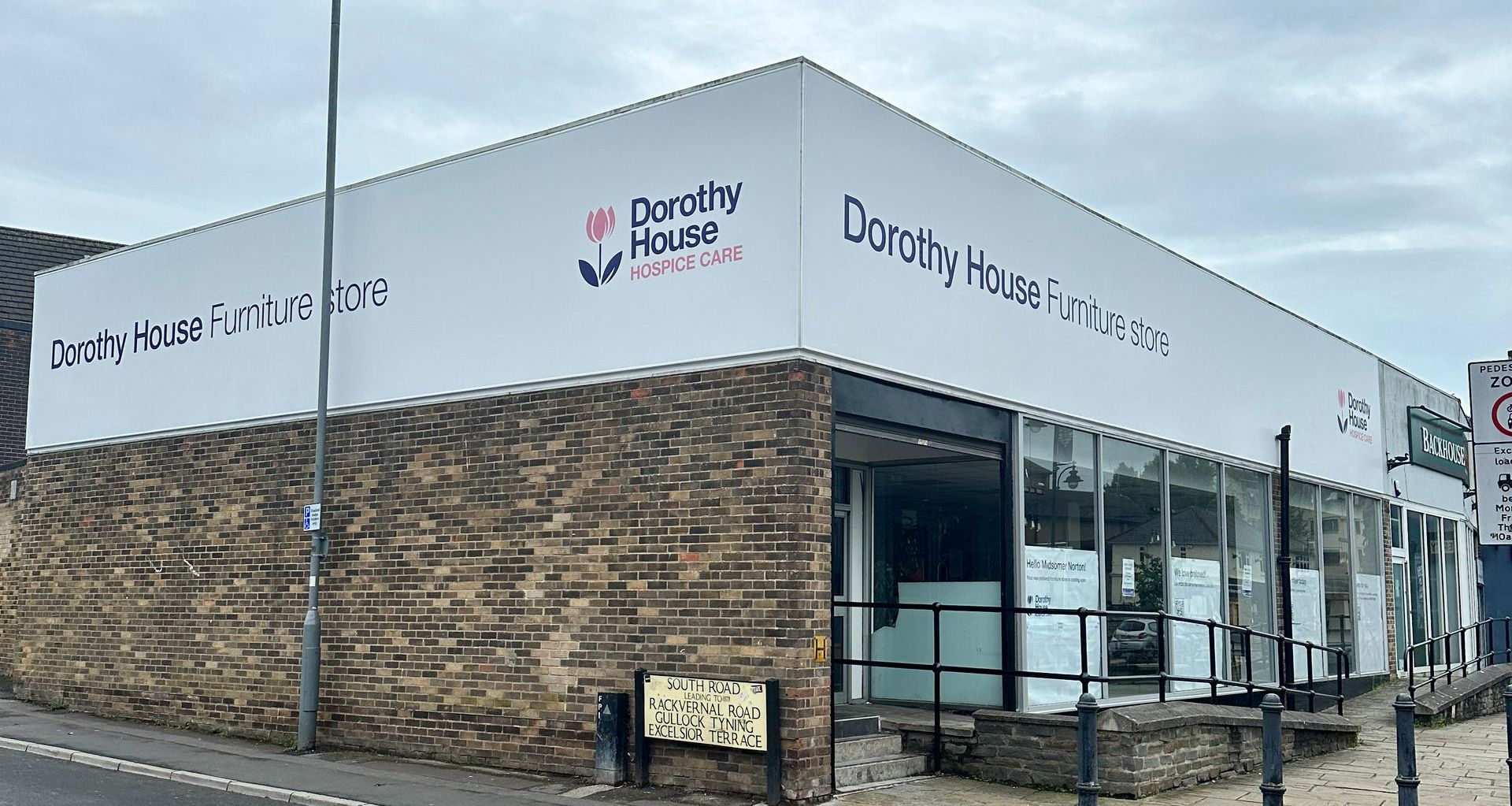 A brick building with a white sign on the side that says dorothy 's house.