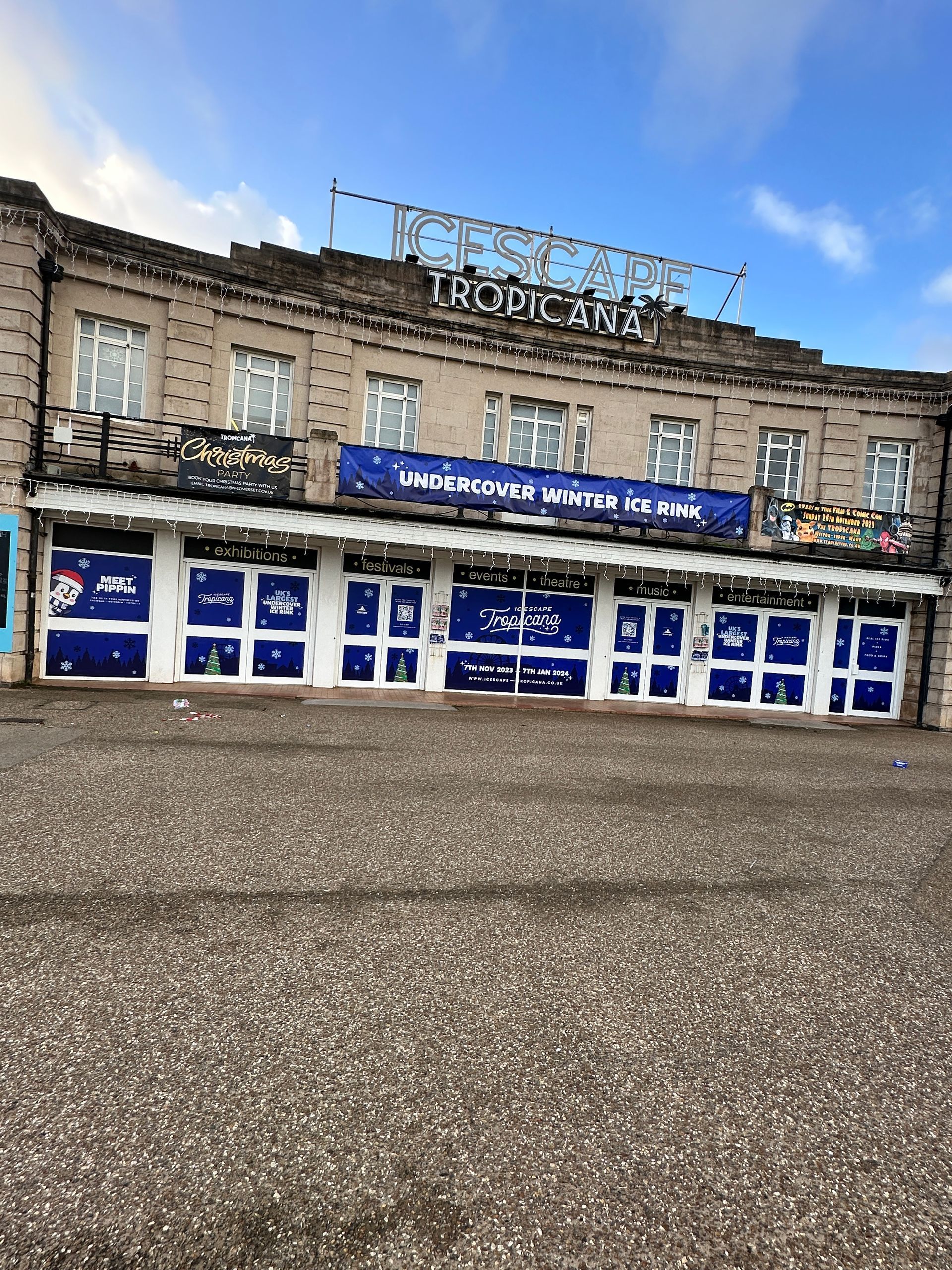 A large building with a lot of windows and a blue sign on top of it.