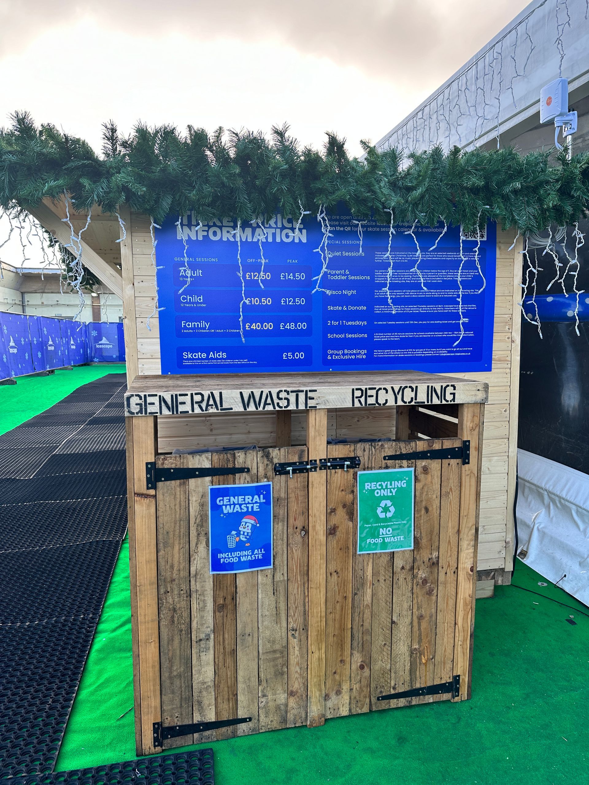 A wooden building with a blue sign that says general waste