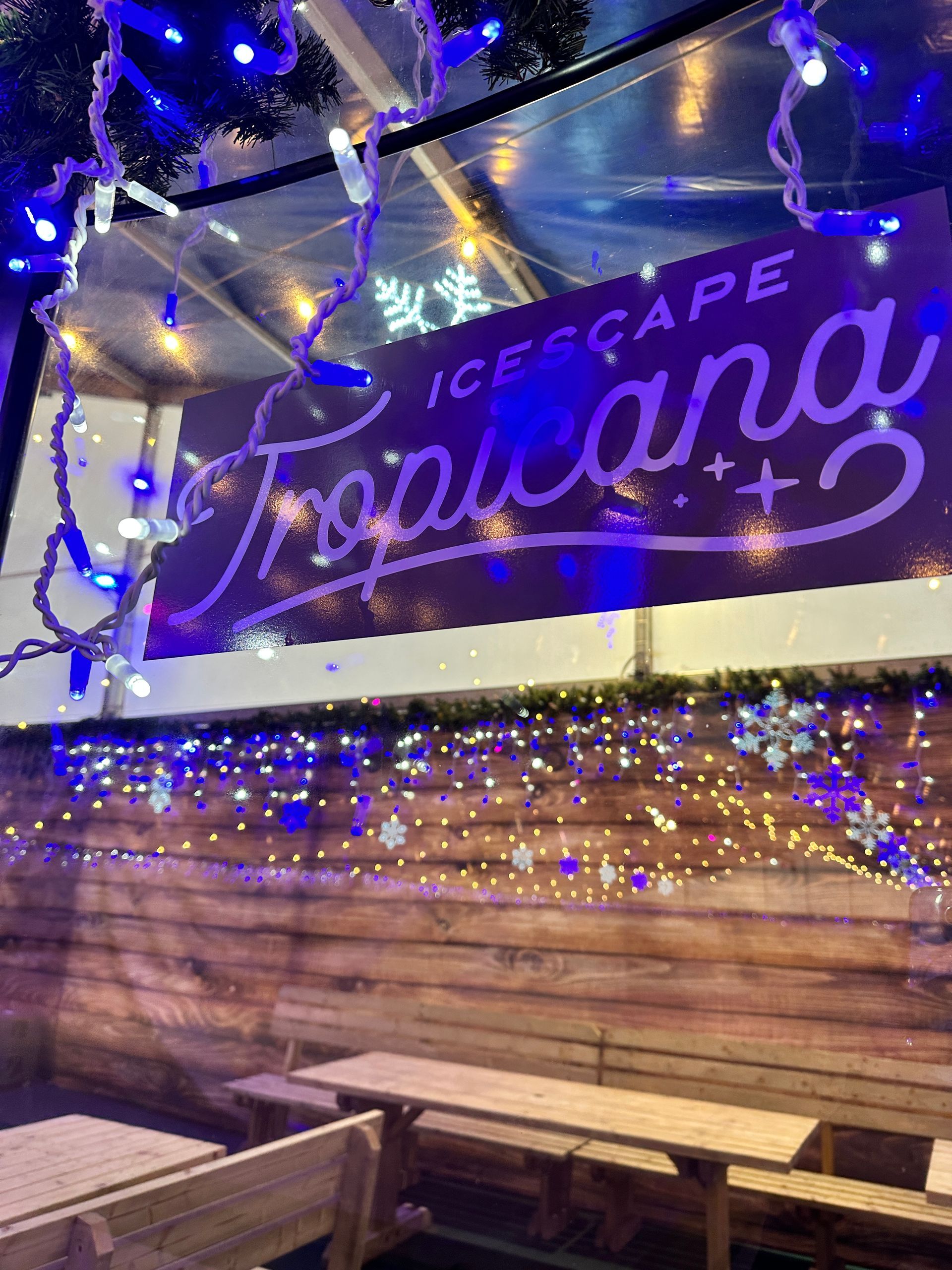 A wooden wall with a sign that says tropicana on it