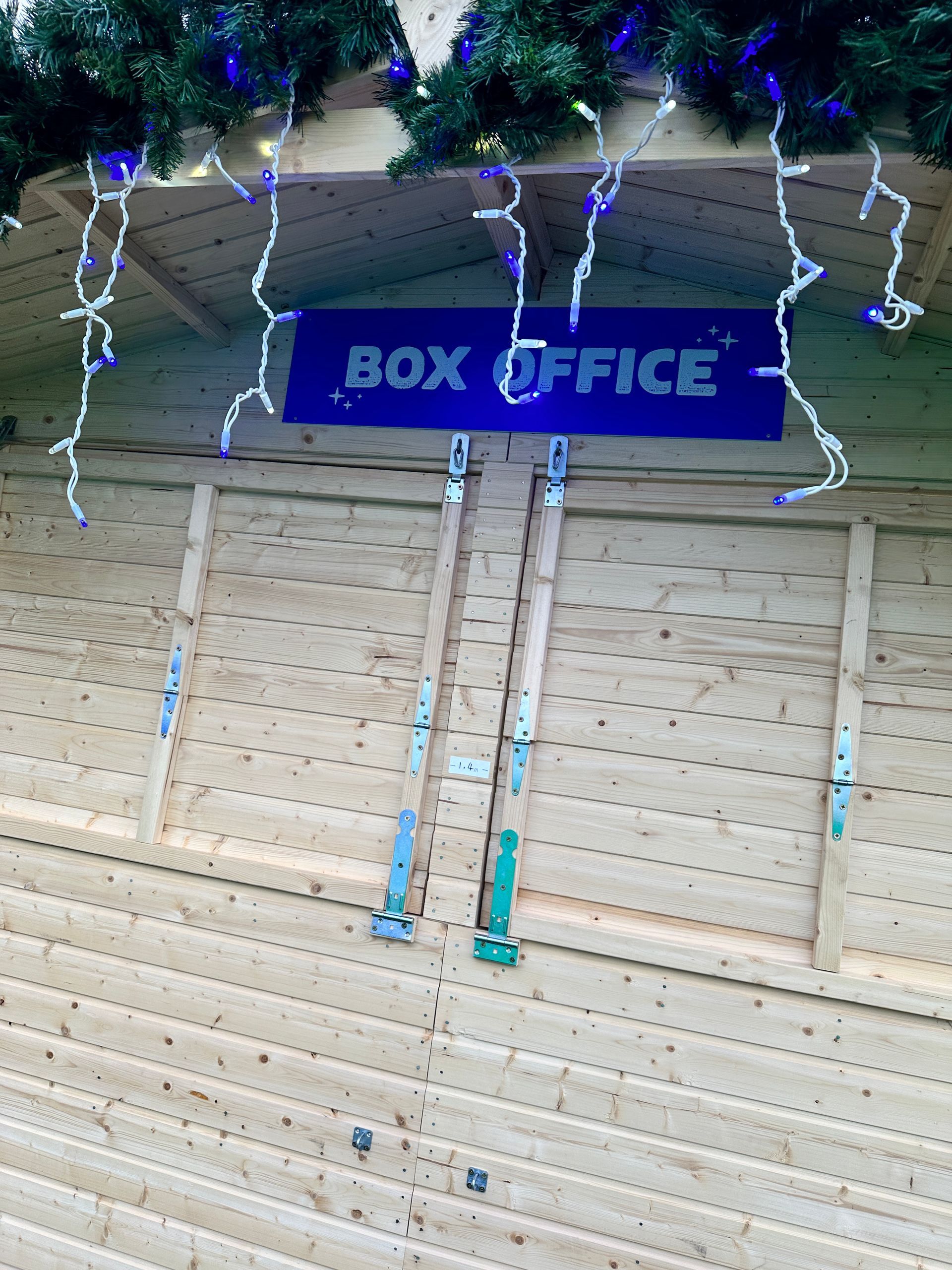A wooden building with a sign that says box office
