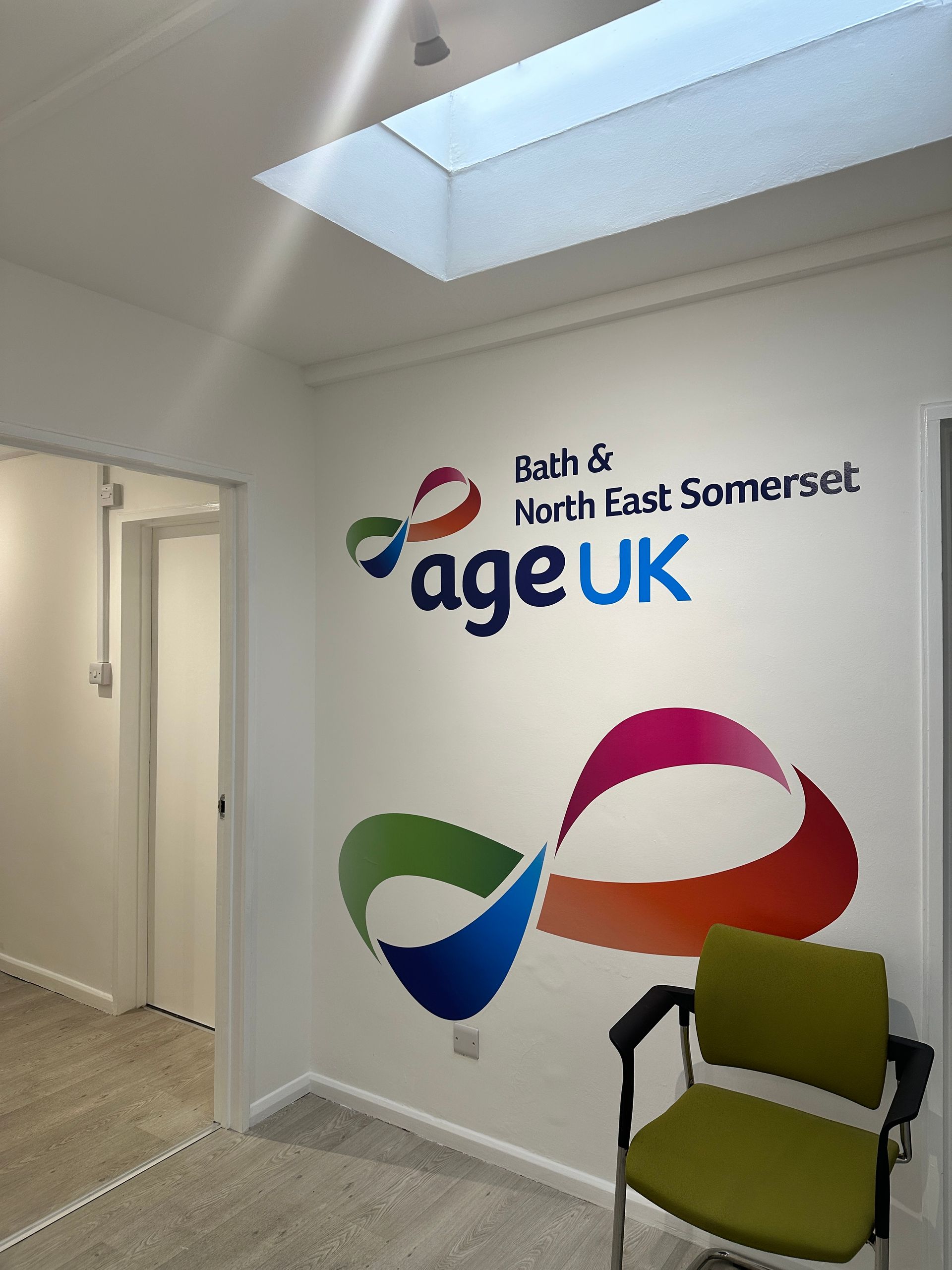 A room with a chair and a sign that says ageuk